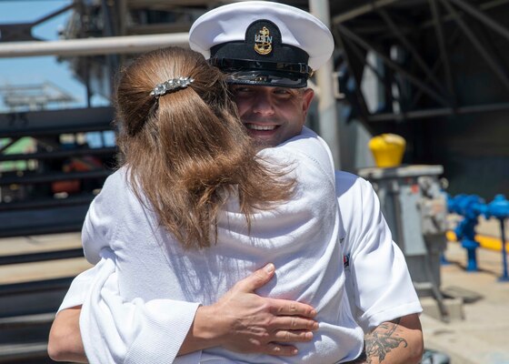 Chief Aviation Electronics Technician Jonathan Mance greets his family on the pier.