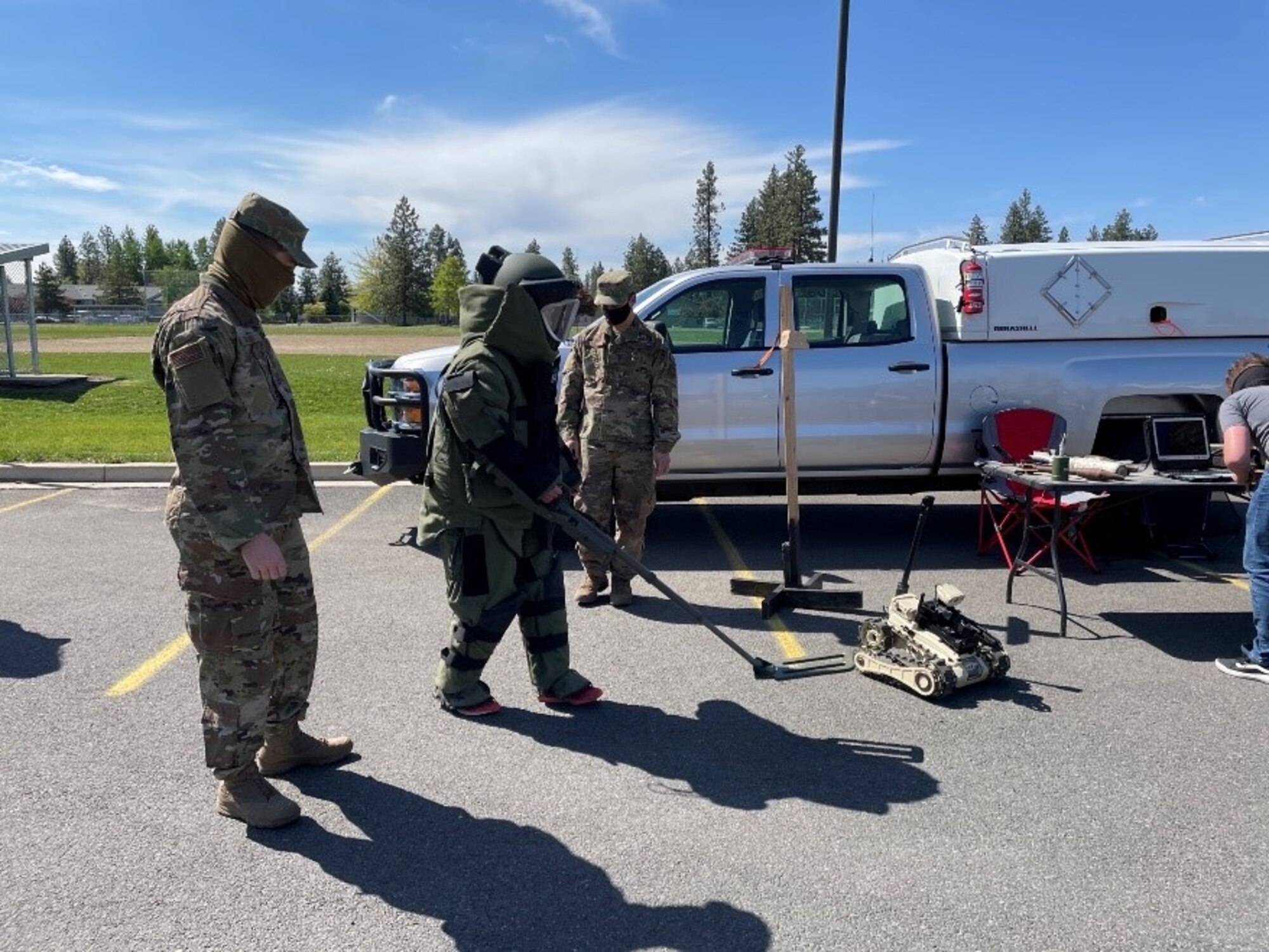 Senior Airman Clayton Ray, 92nd Civil Engineering instructs an eighth-grade student from Medical Lake Middle School on how to wear the “Bomb Suit” at the Explosive Ordnance Disposal booth during STEM Day at Medical Lake Middle School, May 21, 2021.