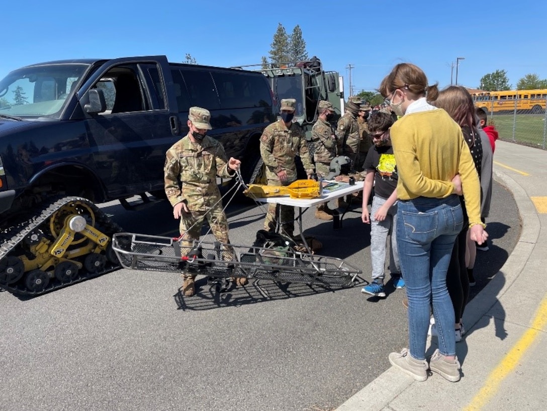 First Lieutenant Nick Vaccarella, 36th Rescue Squadron chief of scheduling, demonstrates how the stokes litter for rescue operations works when hoisted by their helicopters to students of Medical Lake Middle School, May 21, 2021.