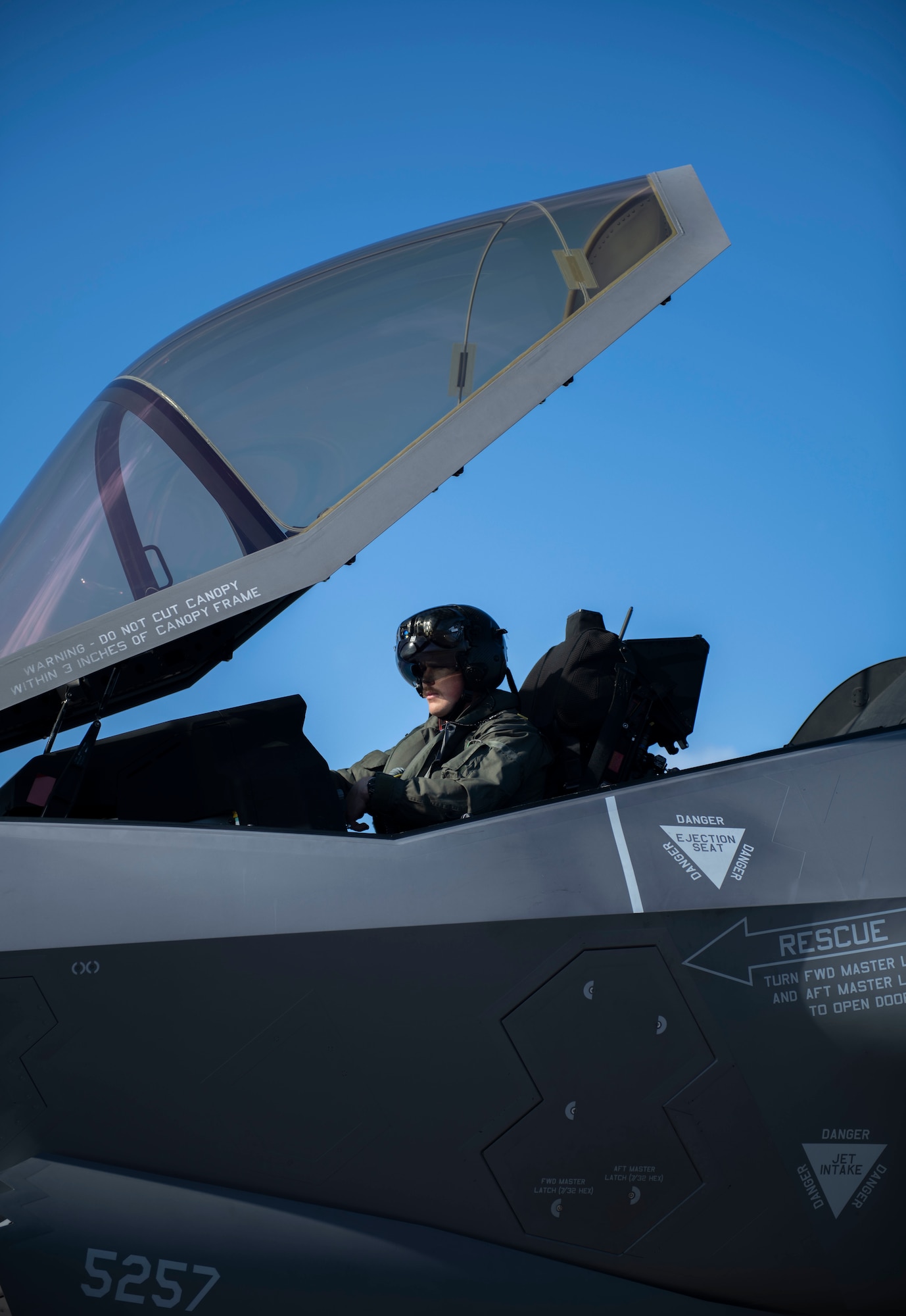 Sideview of a man sitting in the cockpit of a plane