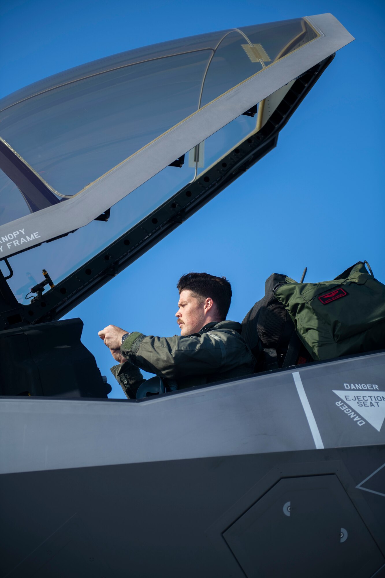 Side view of a man sitting in the cockpit of a plane