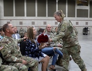 Soldier gives red roses to spouse of outgoing command sergeant major during a change of responsibility cereemony