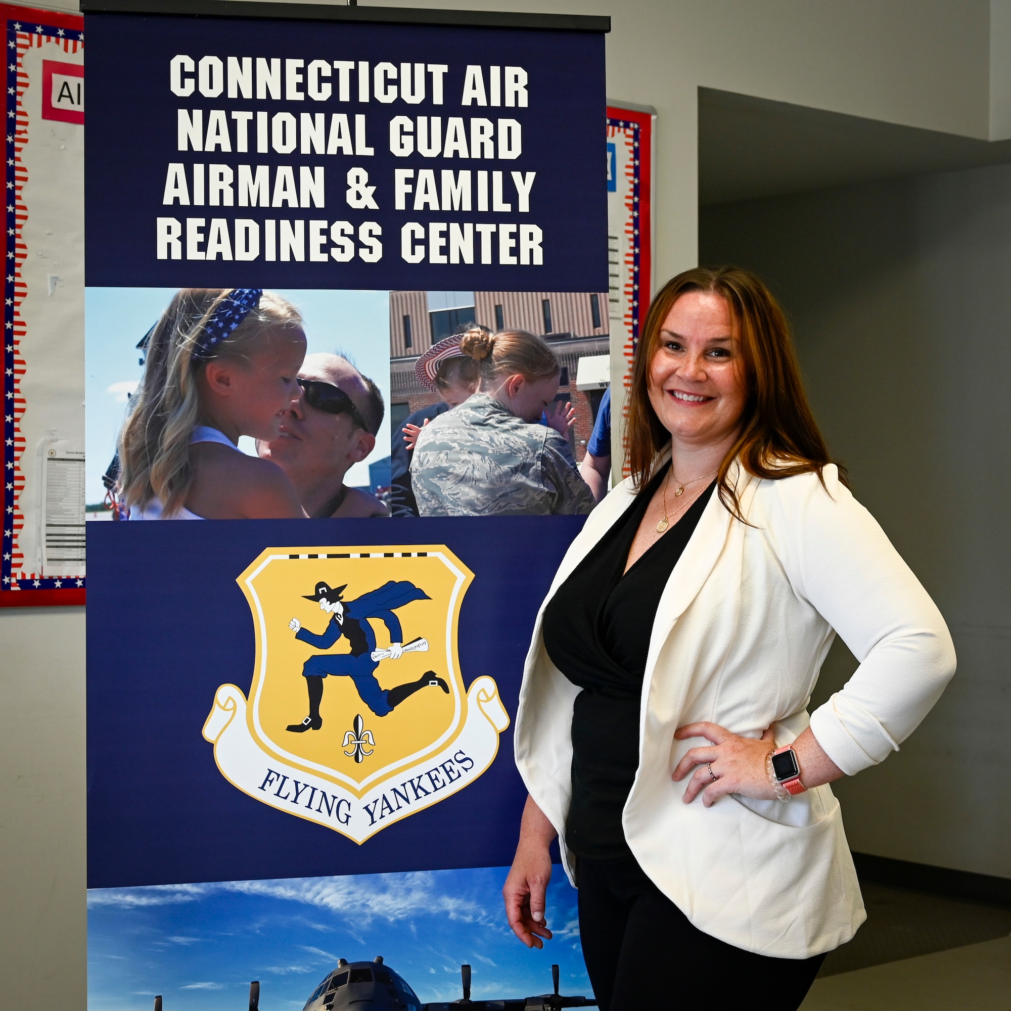 Kasey Timberlake, 103rd Airlift Wing Airman and Family Readiness program manager, outside her office at Bradley Air National Guard Base in East Granby, Connecticut, May 25, 2021. The Airman and Family Readiness program supports members throughout their military life cycle, from student flight through retirement, and connects them and their families with helping resources throughout the various stages of their careers. (U.S. Air National Guard photo by Tech. Sgt. Steven Tucker)