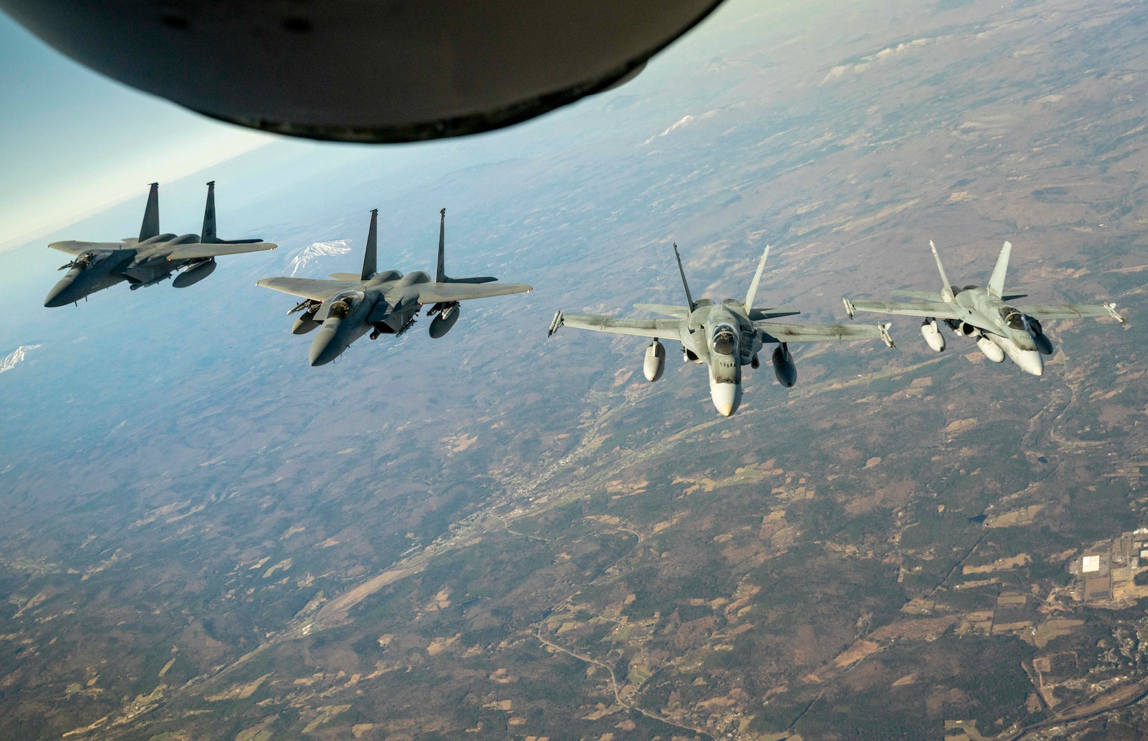 U.S. Air Force F-15 fighters jets from Massachusetts Air National Guard’s 104th Fighter Wing and Royal Canadian Air Force CF-18 fighter jets from 3 Wing, Bagotville, Quebec join up behind a Maine Air National Guard KC-135 Stratotanker from the 101st Air Refueling Wing during a Continental U.S. North American Aerospace Defense Command Region and Canadian NORAD Region cross-border demonstration, April 23, 2020.