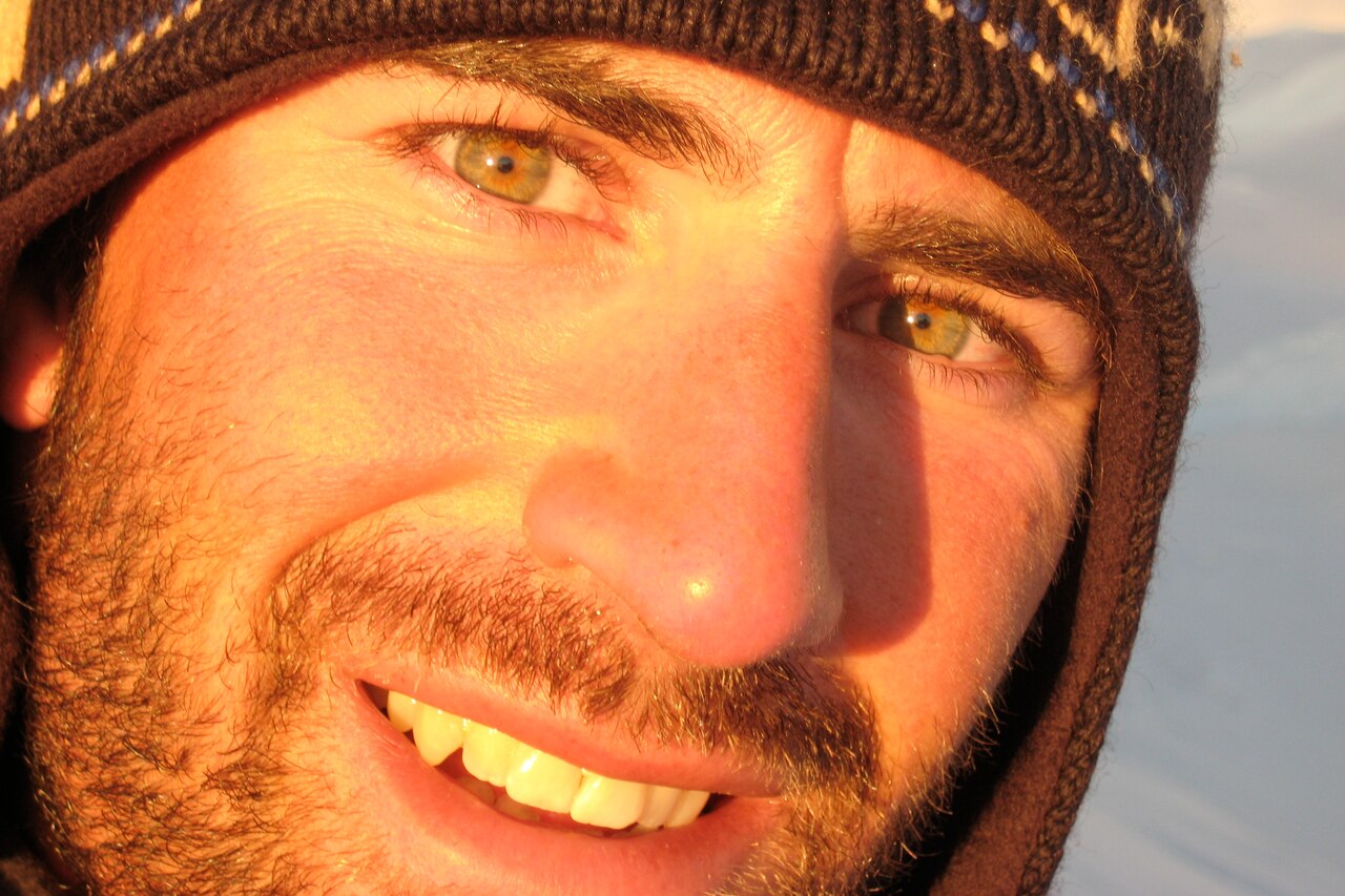 A close-up of the face of a man in a beanie.