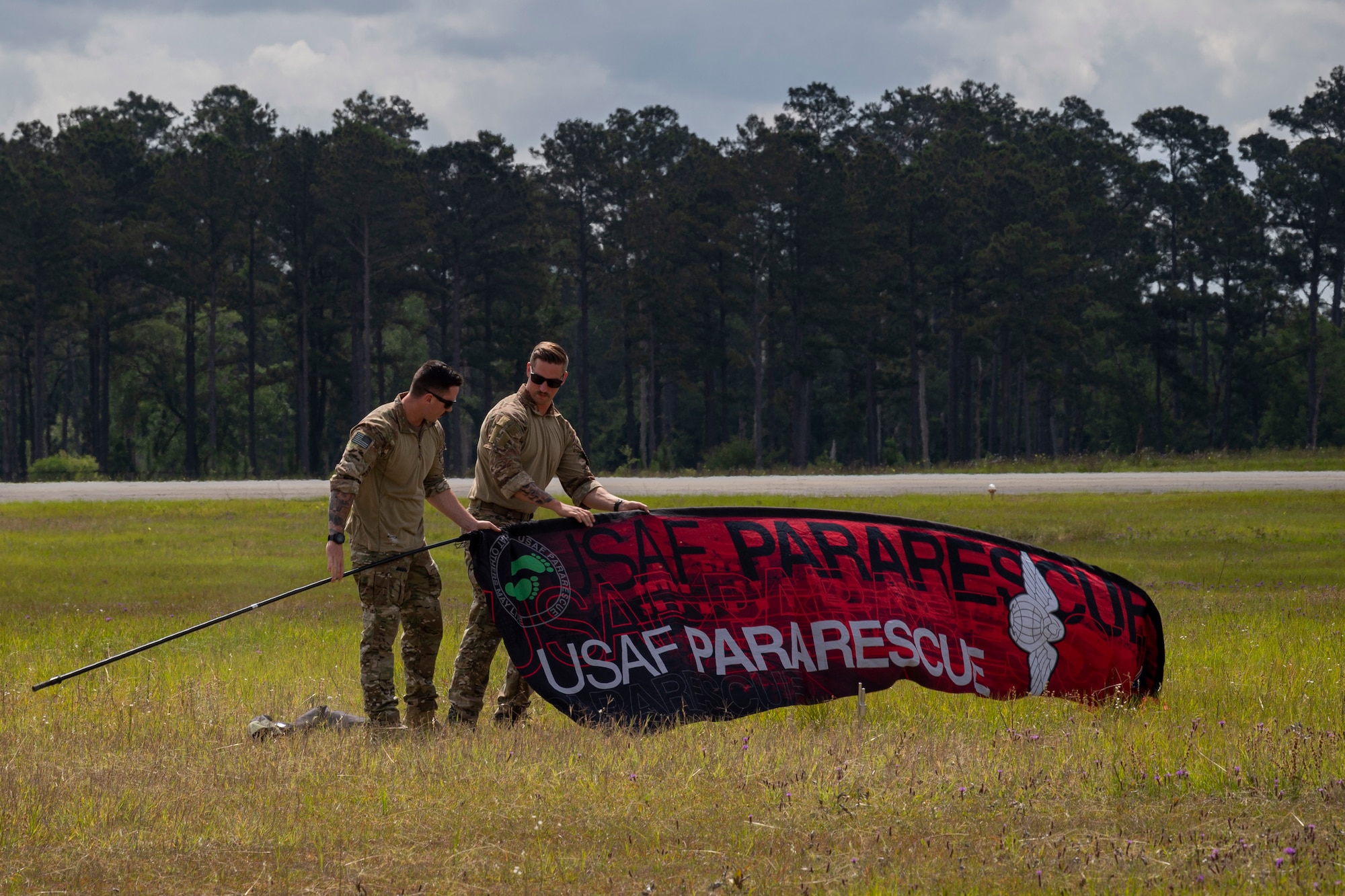 Photo of Airmen preparing to place a flag in the ground