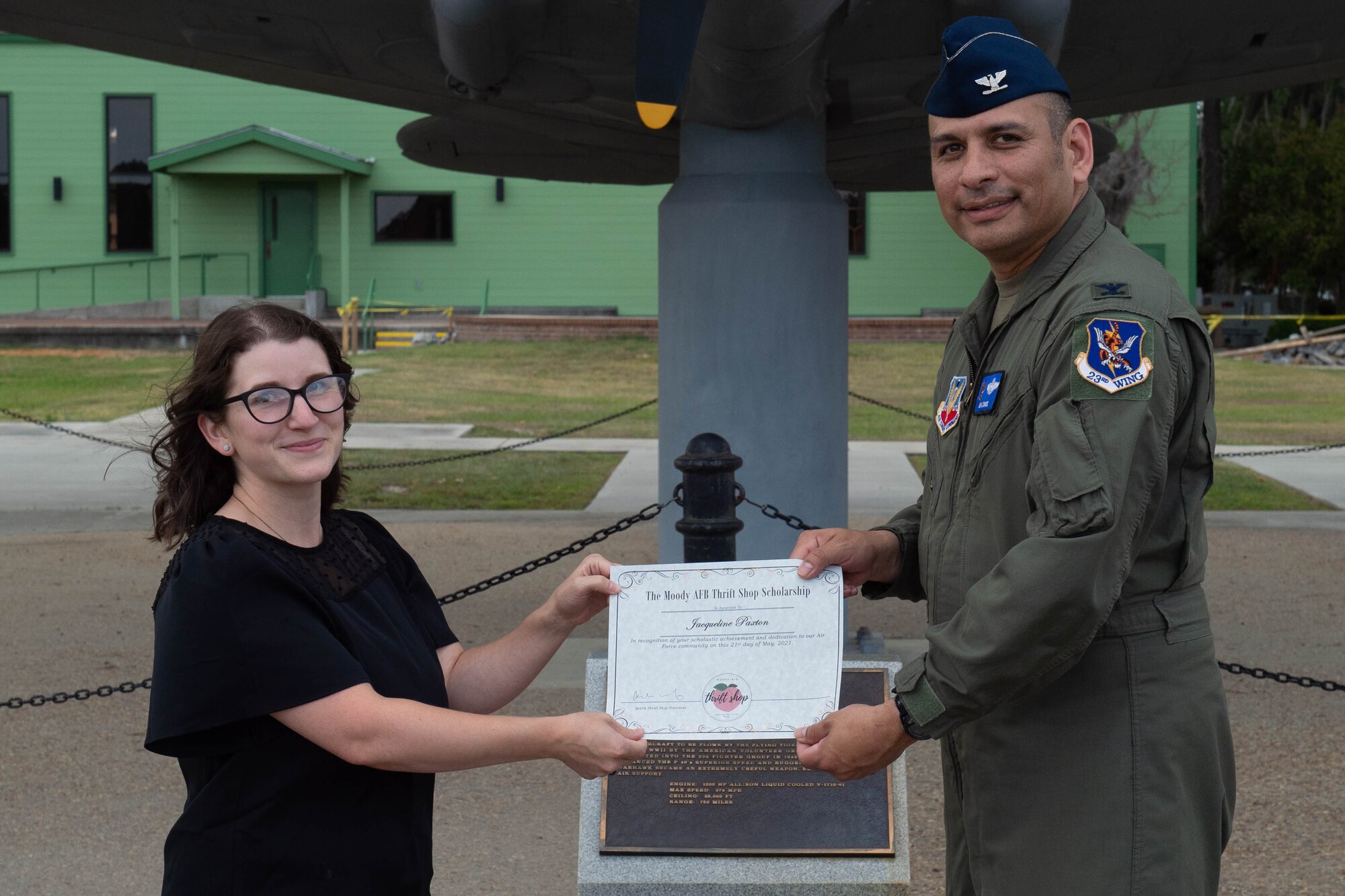 Airmen hands paper to military spouse.