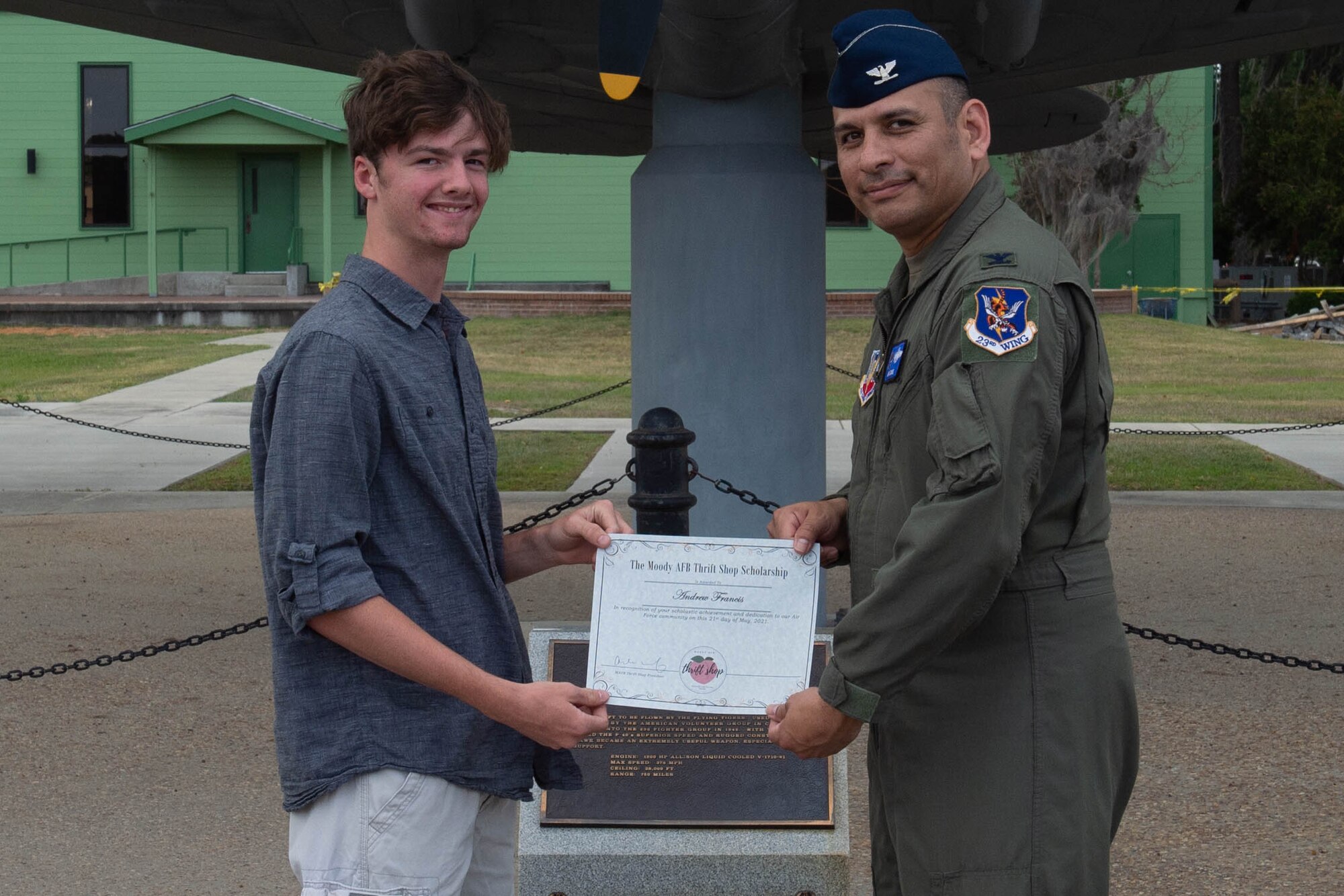 Airmen hands paper to high school student.