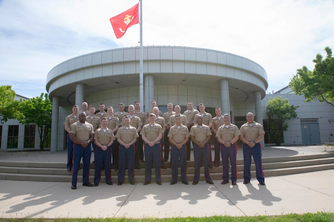 U.S. Marines from 9th Marine Corps District pose for a photo after graduating from the Staff Non-Commissioned Officer in Charge course 3-21 on Naval Station Great Lakes, Ill., May 21, 2021. The course teaches the Marines how to properly lead their respective recruiting sub-stations. (U.S. Marine Corps illustration by Cpl. Baylee Boggs)