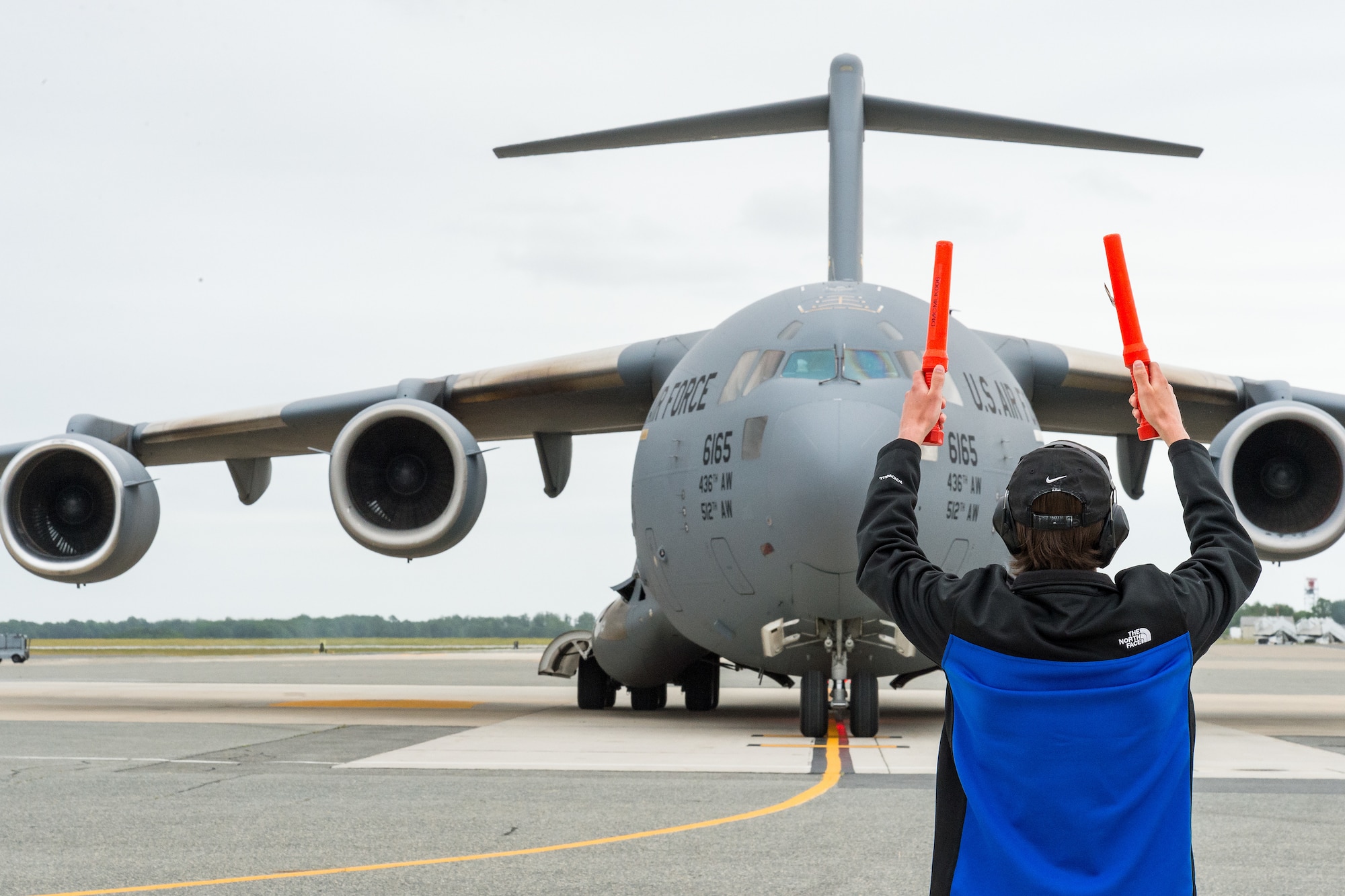 Christopher “CJ” May Jr., son of Col. Christopher May, 436th Maintenance Group commander, marshals a C-17 Globemaster III into its parking spot at Dover Air Force Base, Delaware, May 24, 2021. After the completion of his “fini flight”, May received the traditional hose-down from family, friends and base personnel. May is retiring after serving 33 years in the Air Force. (U.S. Air Force photo by Roland Balik)