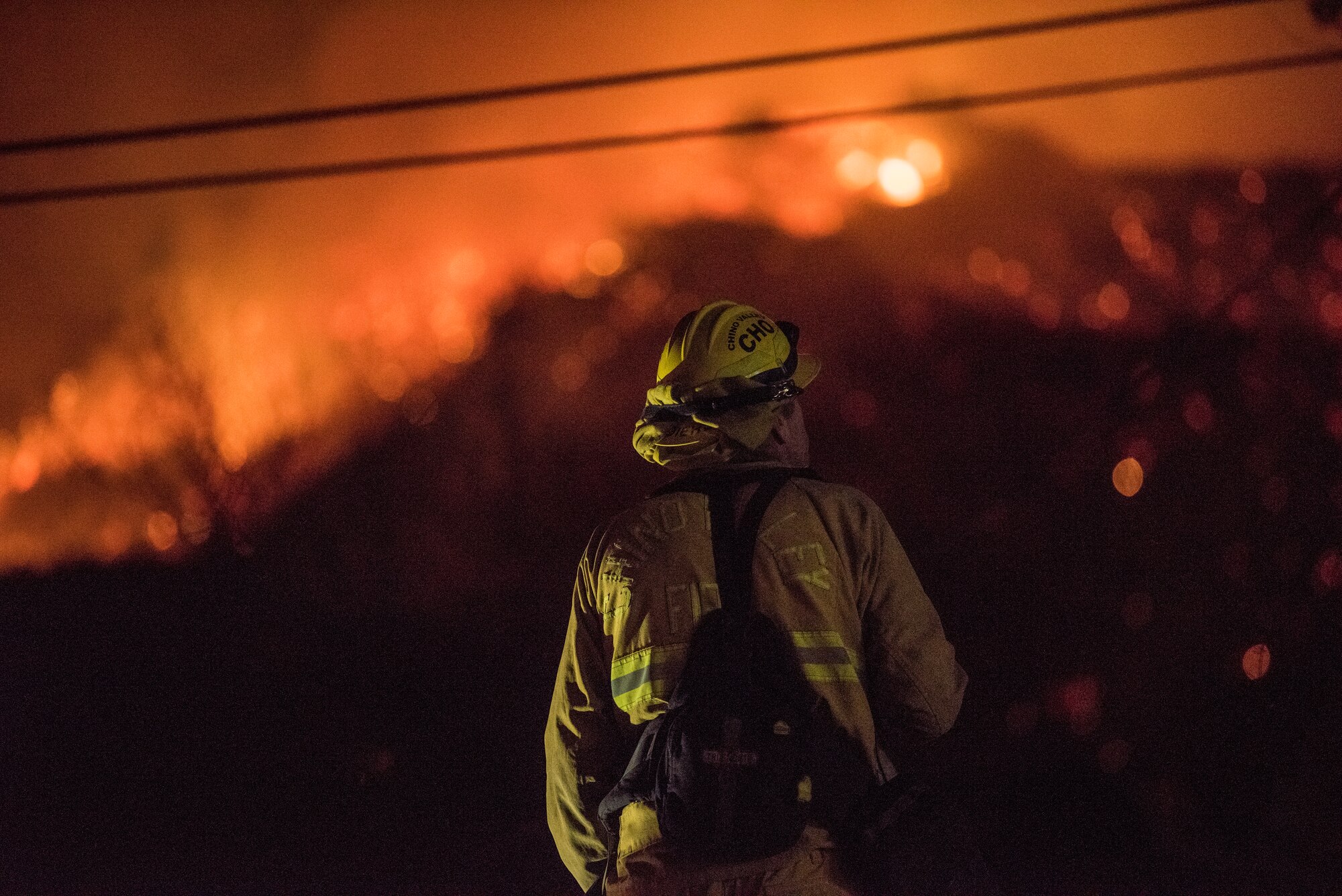 Chino Valley firefighters watch the oncoming flames of the Thomas Fire from the yard of a home in Montecito, California, Dec. 12, 2017. C-130Js of the 146th Airlift Wing at Channel Islands Air National Guard Base in Port Hueneme, carried the Modular Airborne Fire Fighting System and dropped fire suppression chemicals onto the fire's path to slow its advance in support of firefighters on the ground. (U.S. Air Force photo by J.M. Eddins Jr.)