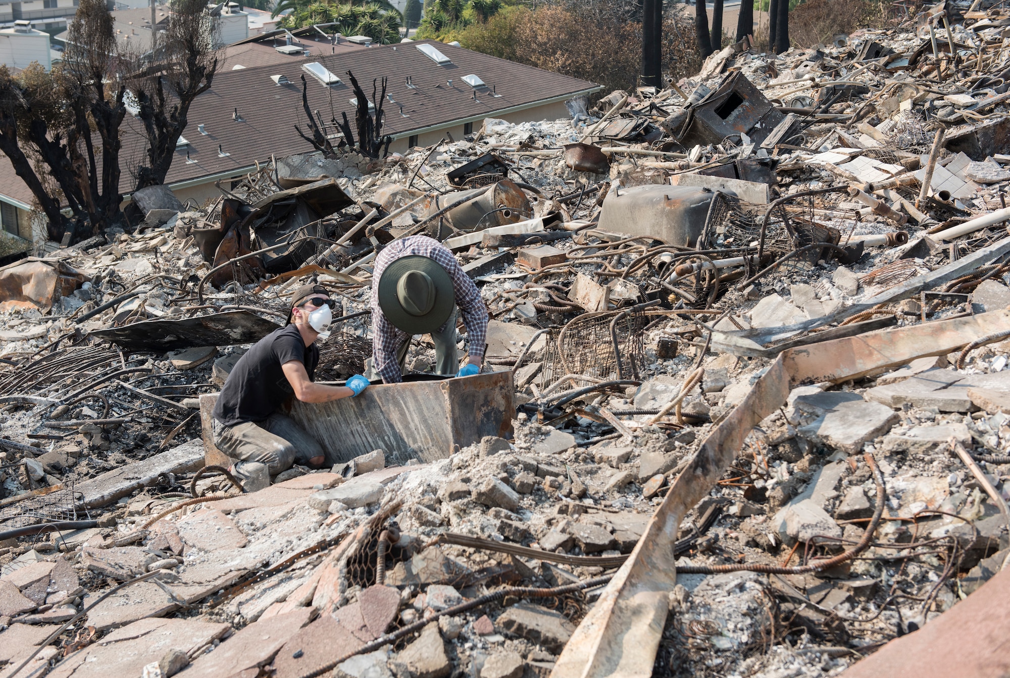 Residents of a 52-unit apartment complex search for belongings, Dec. 13, 2017, after the Thomas Fire roared through their neighborhood. Staff Sgt. Timothy Dawson, a C-130J Hercules aircraft maintenance technician with the 146th Airlift Wing, was also a resident of the apartment complex. The 146 Airlift Wing was activated Dec.5, 2017, to support CAL FIRE with wildfire suppression efforts within the state. (U.S. Air Force photo/Master Sgt. Brian Ferguson)