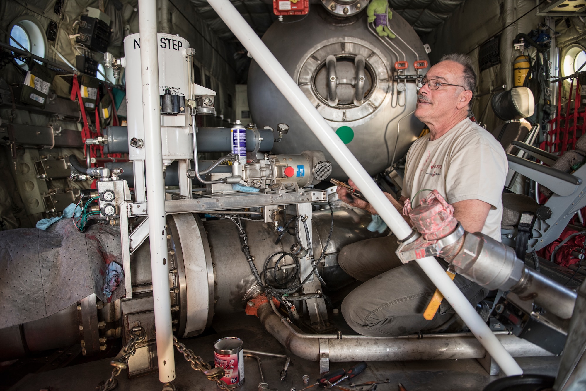 A technicians perform repairs on a Modular Airborne Fire Fighting System (MAFFS) in the cargo bay of a C-130J of the 146th Airlift Wing at Channel Islands Air National Guard Base in Port Hueneme, California, Dec. 9, 2017. The MAFFS units, which are owned by the U.S. Forestry Service, can be loaded and made ready for operations in about three hours. A mixture of water and fire-retardant chemicals is deployed through a nozzle attached to an orange door the replaces the paratroop door on the C-130J.(U.S. Air Force photo)