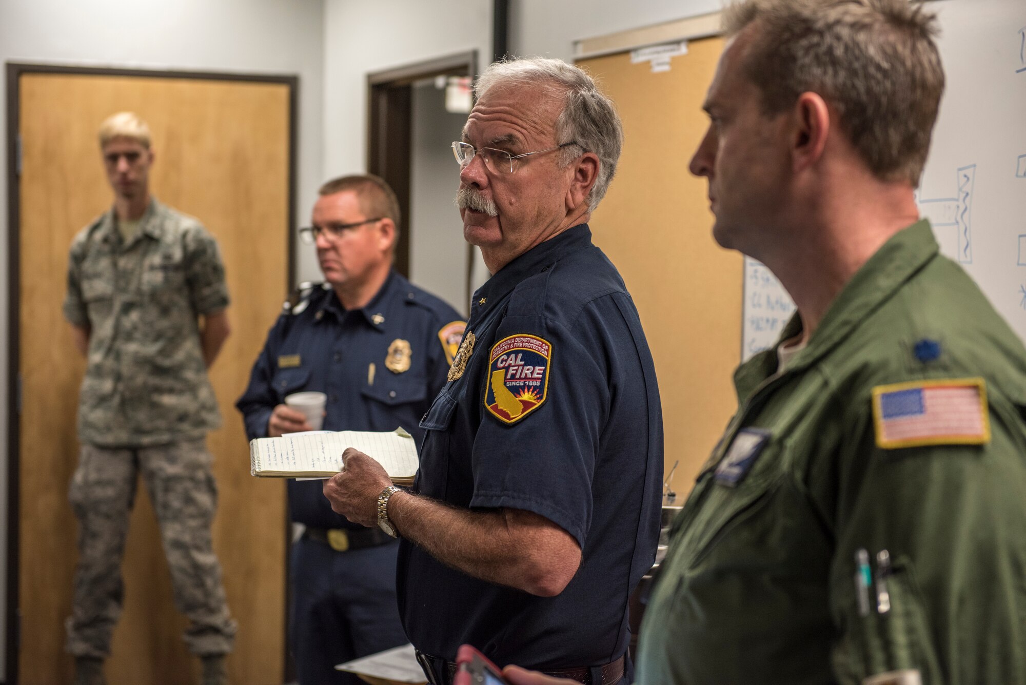 Cal Fire coordinators and the 146th Airlift Wing mission commander brief C-130J pilots and crews at Channel Islands Air National Guard Base in Port Hueneme, California, Dec. 10, 2017, for aerial operations to contain the Thomas Fire burning across Ventura and Santa Barbara Counties. The aircraft carry the Modular Airborne Fire Fighting System to drop fire suppression chemicals across the path of the wildfire to slow and contain the flames. (U.S. Air Force photo by J.M. Eddins Jr.)