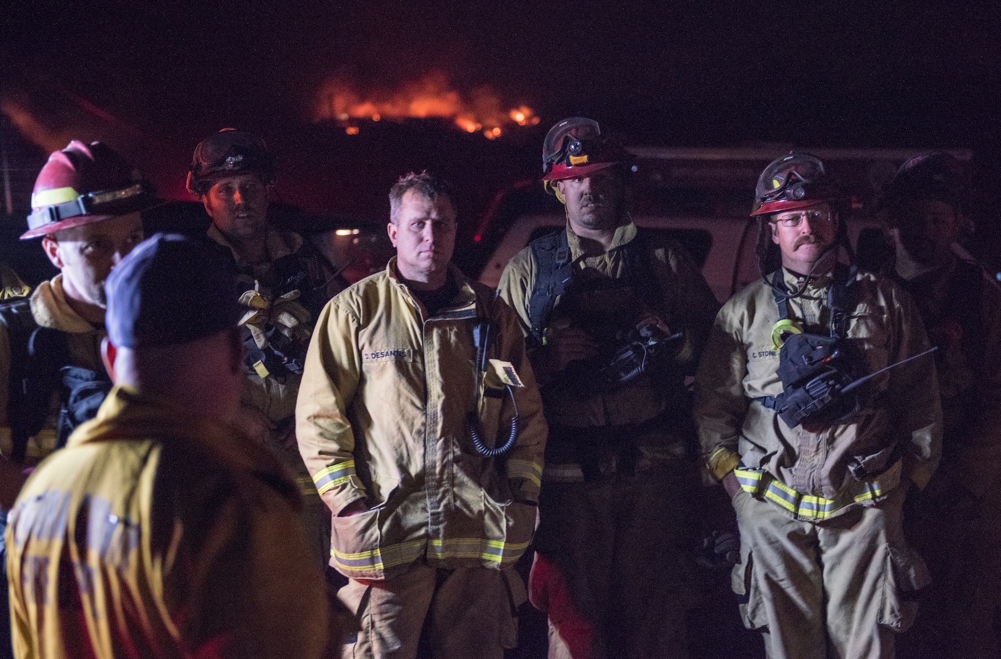 Firefighters assemble before performing a controlled burn to starve the Thomas Fire of fuel, Dec. 10, 2017. Fire crews on the ground dig firebreaks and then call in aircraft, such as the C-130Js of the 146th Airlift Wing at Channel Islands Air National Guard Base in Port Hueneme, California, to drop fire suppression chemicals across the path of wildfires. If winds are calm enough, the firefighters will then burn away foliage in the fire's path to starve it of fuel and stop its advance. (U.S. Air Force photo by J.M. Eddins Jr.)