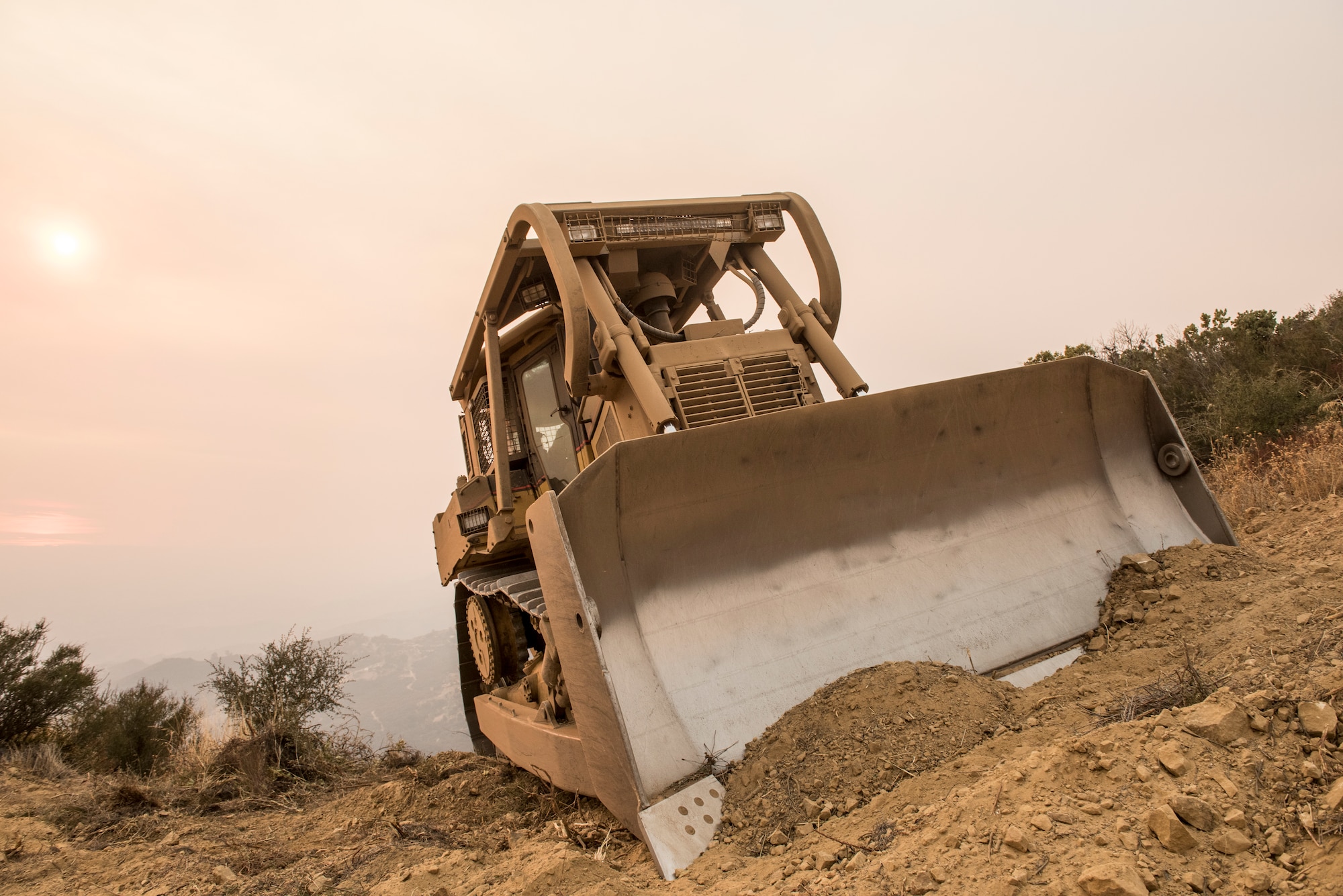 A bulldozer clears a Thomas Fire fire line near Santa Barbara, California, Dec 11, 2017. The Thomas Fire started on Dec. 4, 2017 in Santa Paula, near Thomas Aquinas College. Driven by Santa Ana winds gusting up to 70 mph, the flames screamed across the hillsides toward Ojai, Ventura and Santa Barbara. (U.S. Air Force photo/Master Sgt. Brian Ferguson)