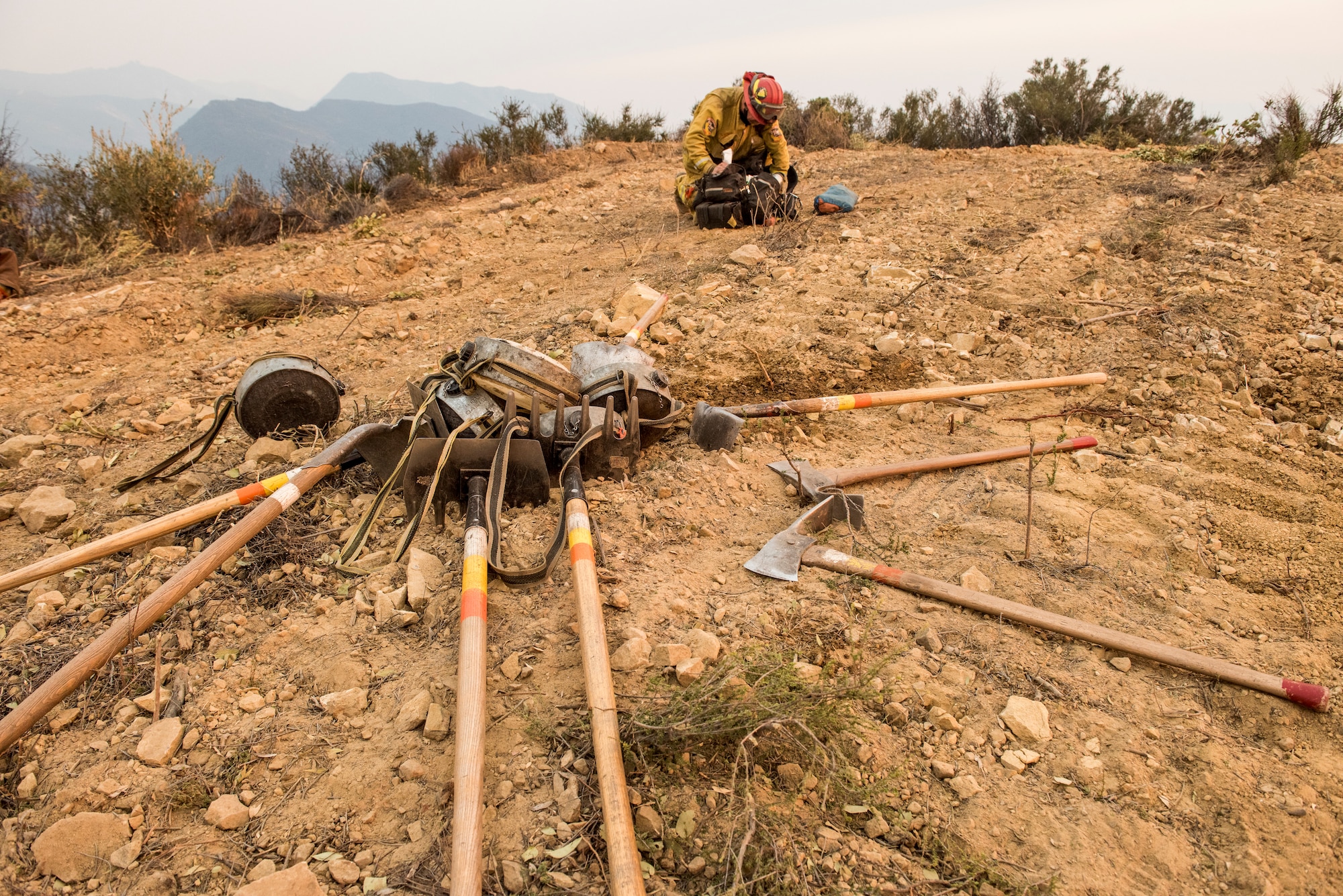 California Department of Corrections inmate fire fighter tools sit in a fire line near Santa Barbara, California, Dec 11, 2017.  The inmates were brought in to help fight the Thomas Fire. The fire started on Dec. 4, 2017 in Santa Paula, near Thomas Aquinas College. Driven by Santa Ana winds gusting up to 70 mph, the flames screamed across the hillsides toward Ojai, Ventura and Santa Barbara. (U.S. Air Force photo/Master Sgt. Brian Ferguson)