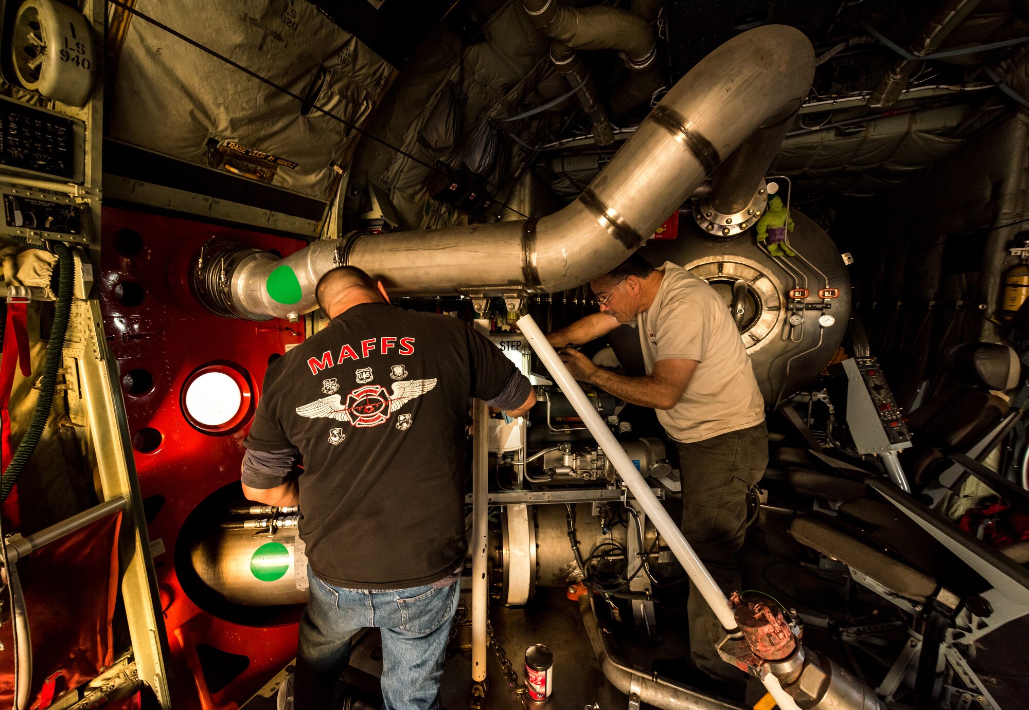 Technicians perform repairs on a Modular Airborne Fire Fighting System (MAFFS) in the cargo bay of a C-130J of the 146th Airlift Wing at Channel Islands Air National Guard Base in Port Hueneme, California, Dec. 9, 2017. The MAFFS units, which are owned by the U.S. Forestry Service, can be loaded and made ready for operations in about three hours. A mixture of water and fire-retardant chemicals is deployed through a nozzle attached to an orange door the replaces the paratroop door on the C-130J. (U.S. Air Force photo by J.M. Eddins Jr.)