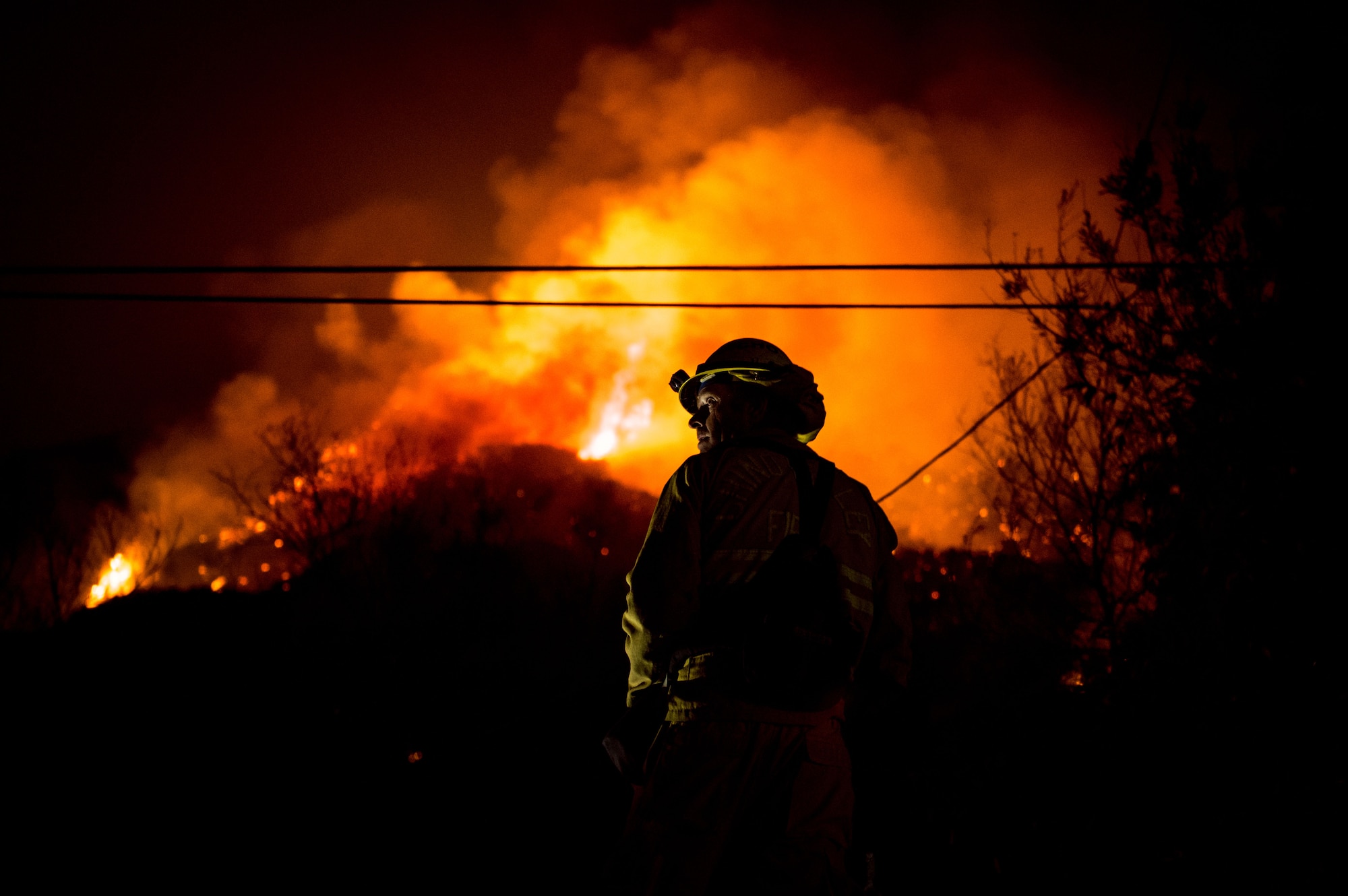 Chino Valley firefighters watch the oncoming flames of the Thomas Fire from the yard of a home in Montecito, California, Dec. 12, 2017. C-130Js of the 146th Airlift Wing at Channel Islands Air National Guard Base in Port Hueneme, carried the Modular Airborne Fire Fighting System and dropped fire suppression chemicals onto the fire's path to slow its advance in support of firefighters on the ground. (U.S. Air Force photo by J.M. Eddins Jr.)