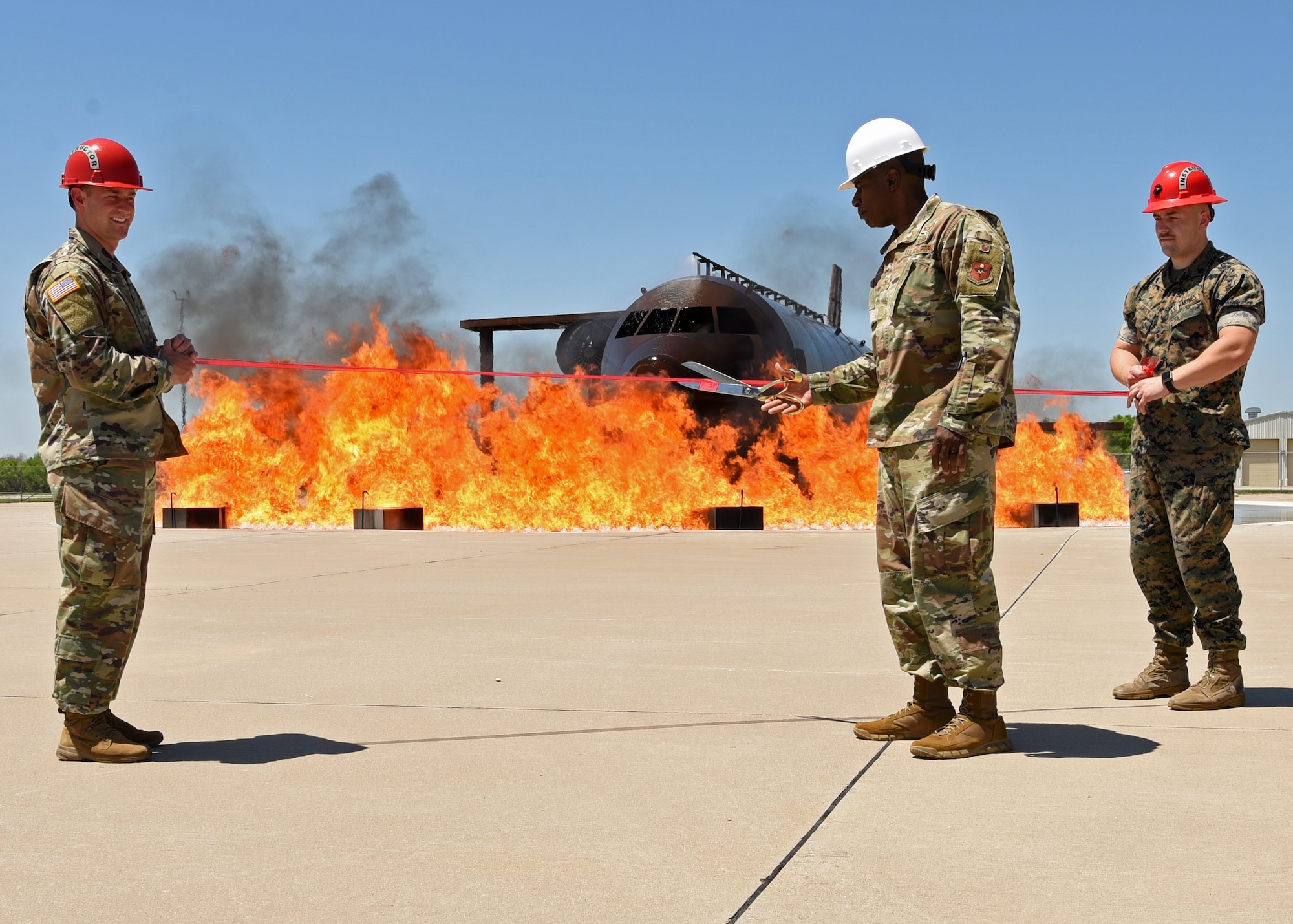 U.S. Air Force Col. James Finlayson, 17th Training Wing vice commander cuts a ribbon, at the Louis F. Garland Department of Defense Fire Academy on Goodfellow Air Force Base, Texas, May 21, 2021. The Training Squadron unveiled over $6 million in new training facilities for instructors and students across the joint forces. (U.S. Air Force photo by Senior Airman Abbey Rieves)