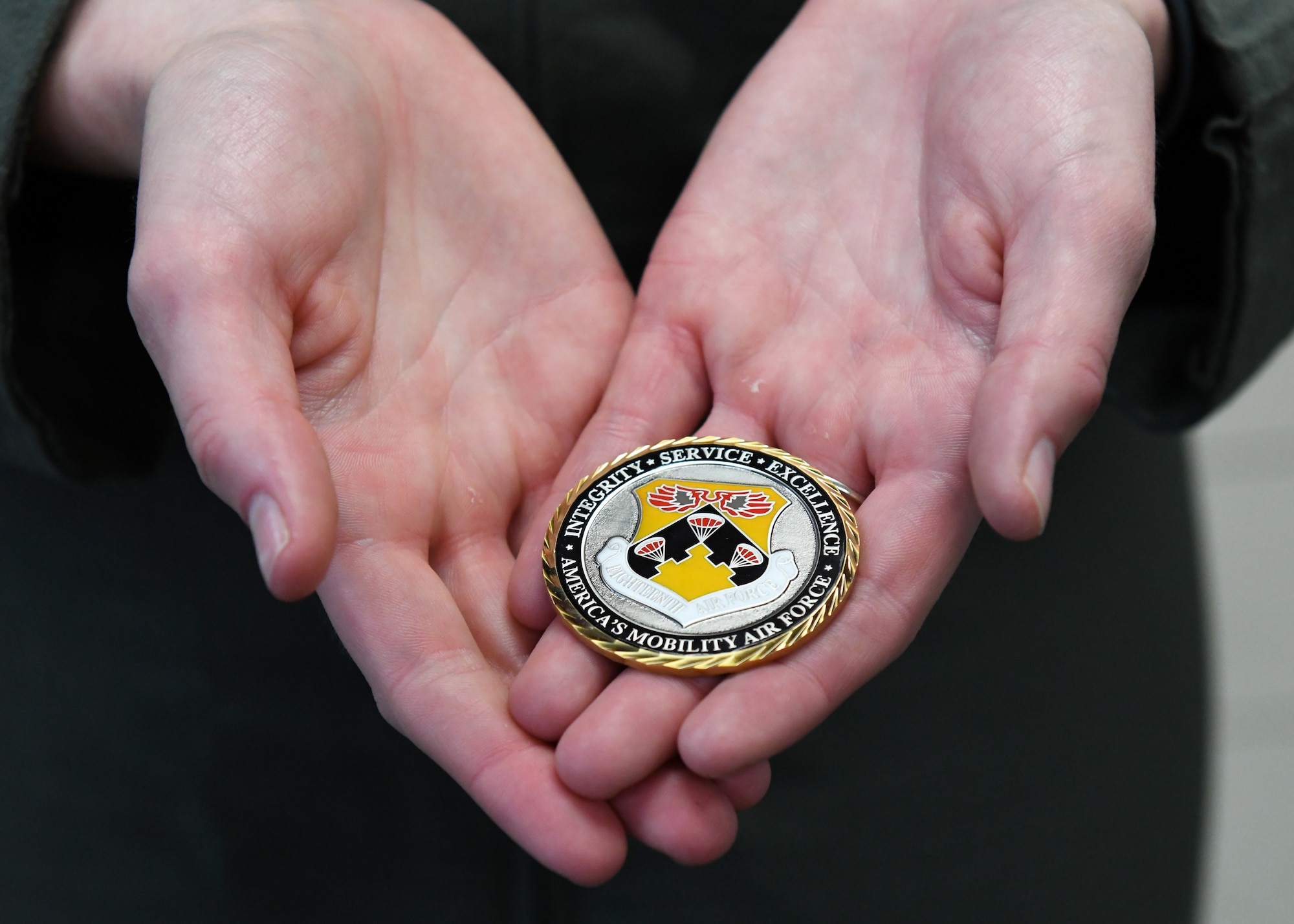 An Airman holds a coin recently given to them by Maj. Gen. Thad Bibb, 18th Air Force commander, during a visit to Fairchild Air Force Base, Washington, May 19-21, 2021.