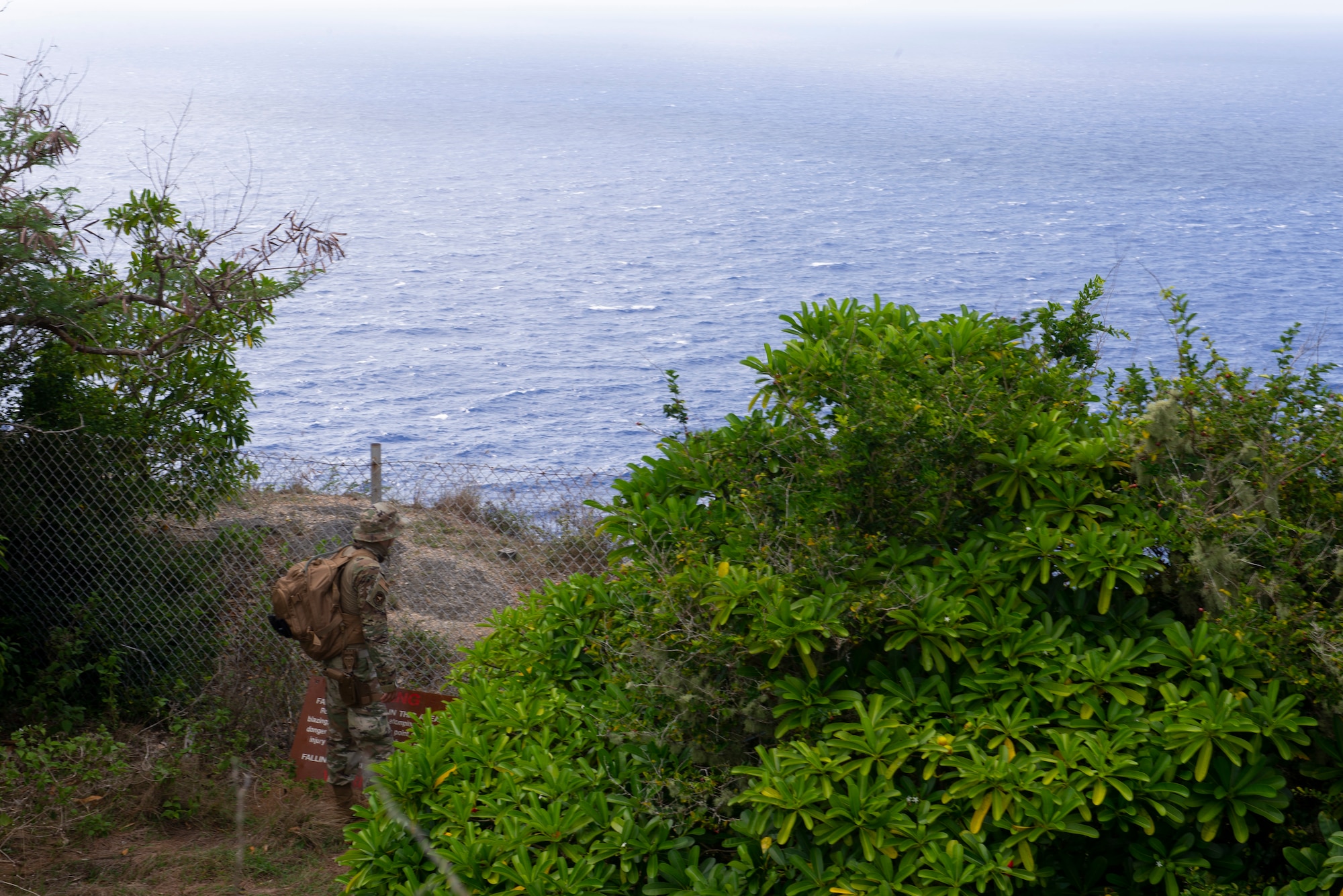Tech. Sgt. Adam Rogers assigned to the 36th Security Forces Squadron performs a ground tasking operation overlooking a cliff face searching for signs of human activity along the eastern shoreline on Andersen Air Force Base, Guam May 14 2021. Andersen Air Force Base covers 14,600 acres, more than half of which is undeveloped land. (U.S. Air Force photo by SSgt Nicholas Crisp)