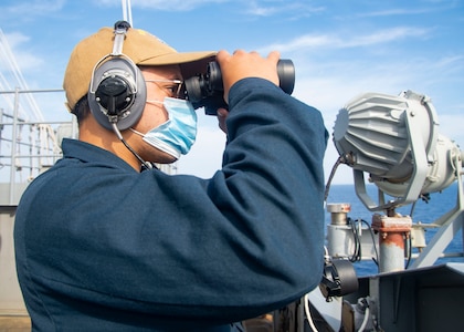 Seaman Emmanuel Laboy, from Patterson, New Jersey, stands lookout watch on the signal bridge of the Nimitz-class aircraft carrier USS Harry S. Truman (CVN 75) during sea trials after completing an extended incremental availability.