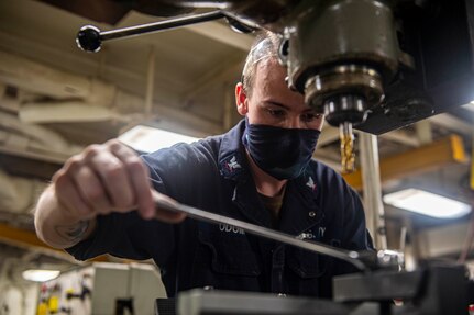 Machinery Repairman 3rd Class John Odom, from Flomaton, Alabama, prepares for a milling operation on an aluminum rail in the repair shop aboard the Nimitz-class aircraft carrier USS Harry S. Truman (CVN 75) during sea trials after completing an extended carrier incremental availability.