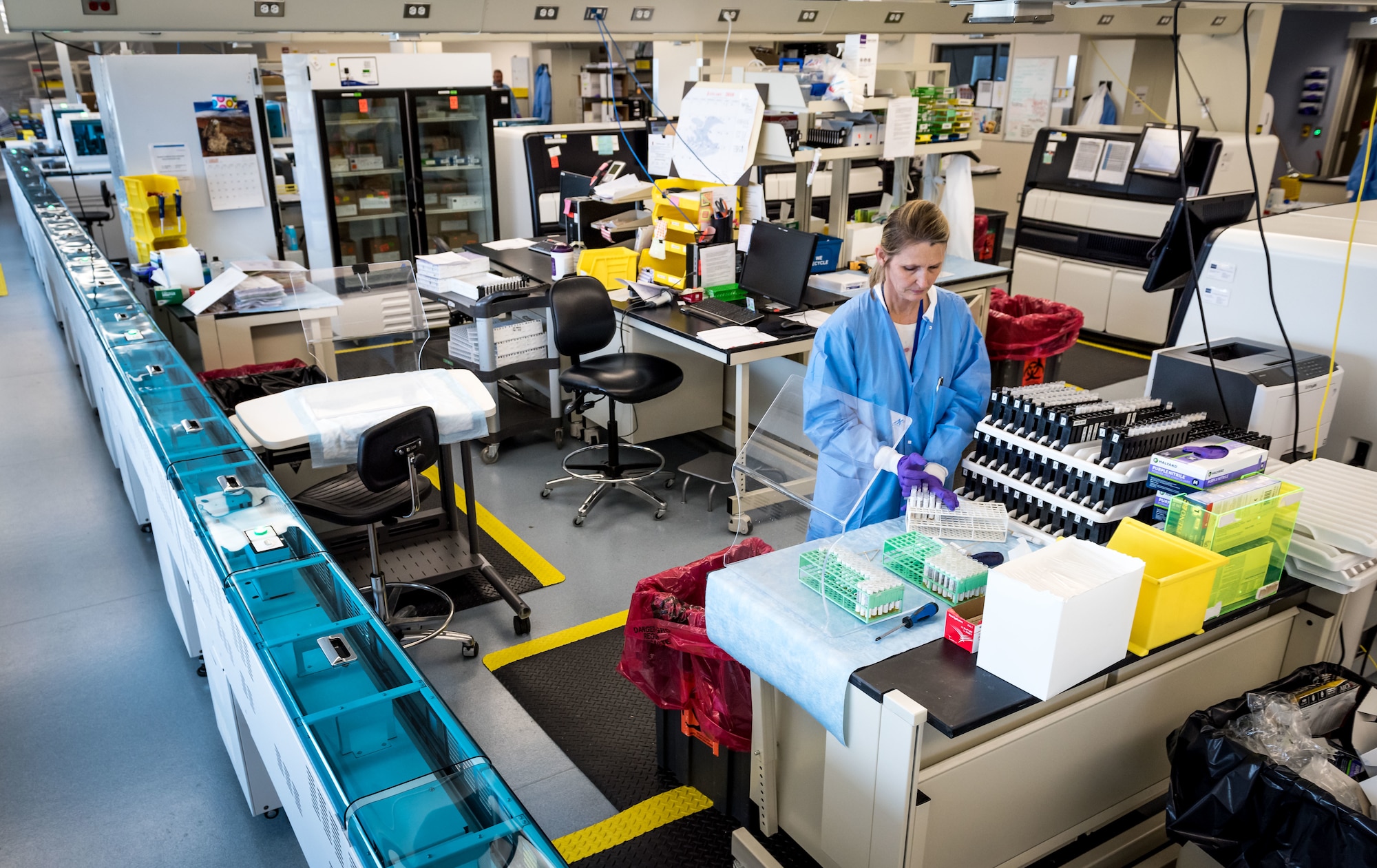 Lisa Fries, laboratory technician, works with serology samples in the immunodiagnostic section of the Epidemiology Laboratory Service, also known as the �Epi Lab,� at the 711th Human Performance Wing�s United States Air Force School of Aerospace Medicine Public Health at Wright Patterson AFB, Ohio, Jan. 30, 2018. The immunodiagnostic section recently installed an automated testing unit, blue track on left, which is computer controlled to prepare samples and transfer them to the appropriate analyzer for STD screening, status-immune testing or other analyses. The system automatically report results to Department of Defense clinics around the world, usually within 48 hours of a sample being shipped to the lab. (U.S. Air Force photo by J.M. Eddins Jr.)