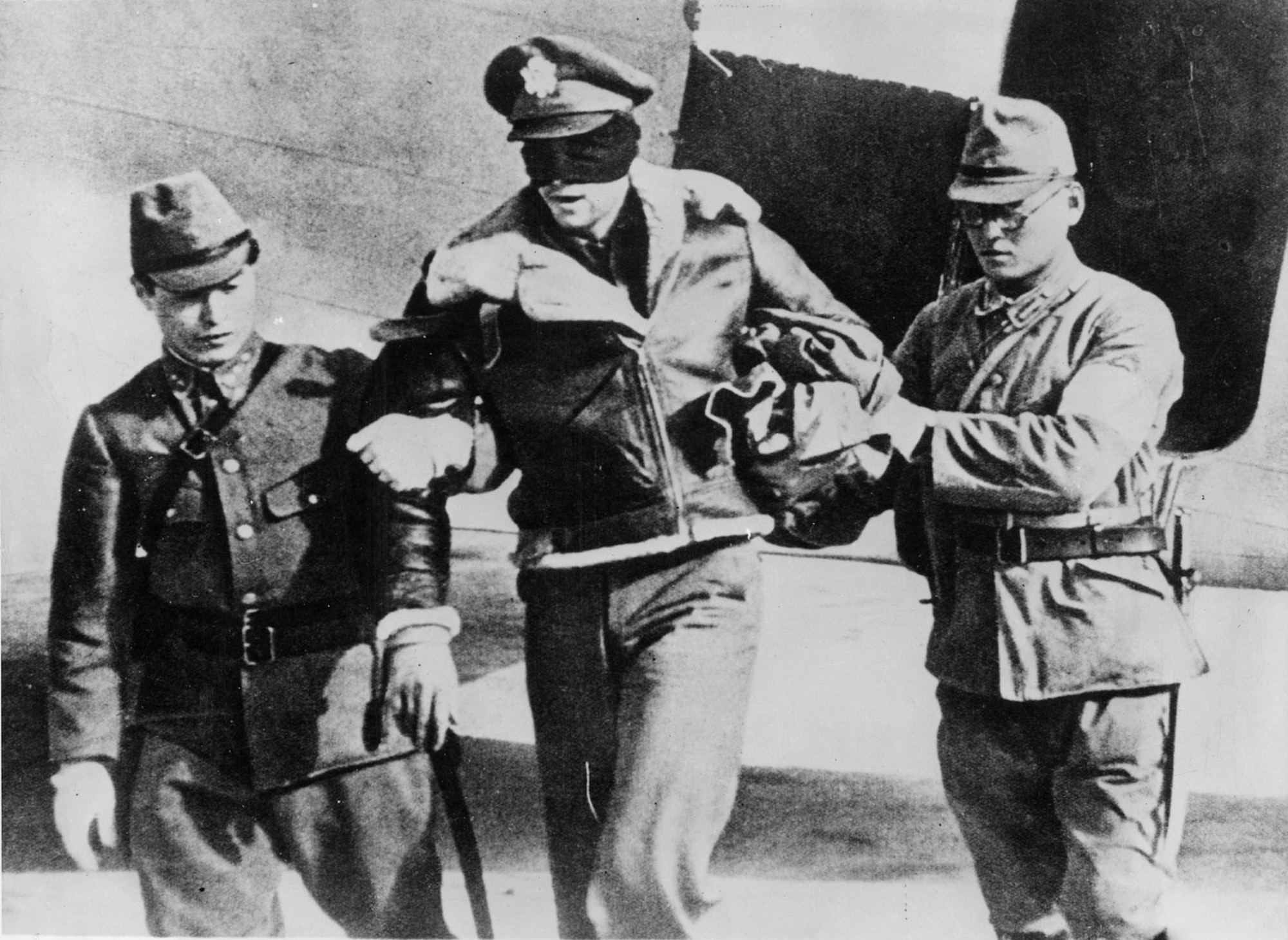 In a photograph found after Japan's surrender in 1945, Lt. Robert L. Hite, copilot of crew 16, is led blindfolded from a Japanese transport aircraft after his B-25 crash landed in a China after bombing Nagoya on the the "Doolittle Raid" on Japan and he was captured. He was imprisoned for 40 months, but survived the war.