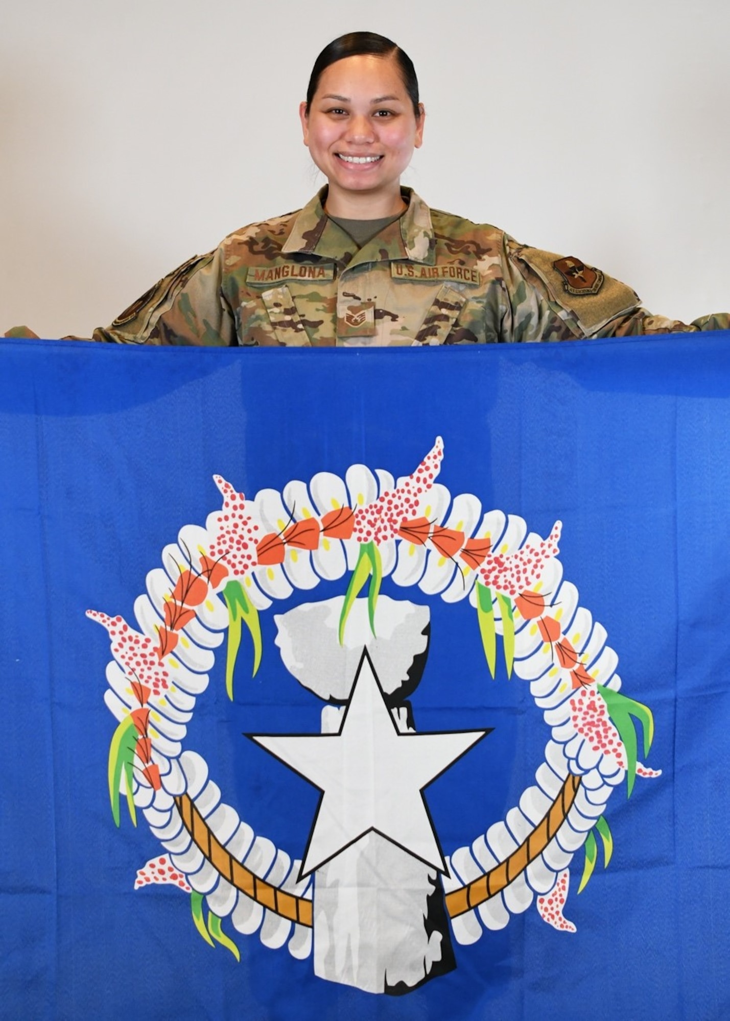 Staff Sgt. Conralyn Manglona, 56th Communications Squadron knowledge management technician, holds the Tinian flag May 24, 2021, at Luke Air Force Base, Arizona. Manglona is from Tinian, one of the islands of the Commonwealth of the Northern Mariana Islands. Diversity and inclusion in the U.S. Air Force are warfighting imperatives capitalizing on all available talent by enabling a culture where all Airmen are valued and respected for their identity, culture and background. (U.S. Air Force photo by Senior Airman Caitlin Diaz-Gorsi)