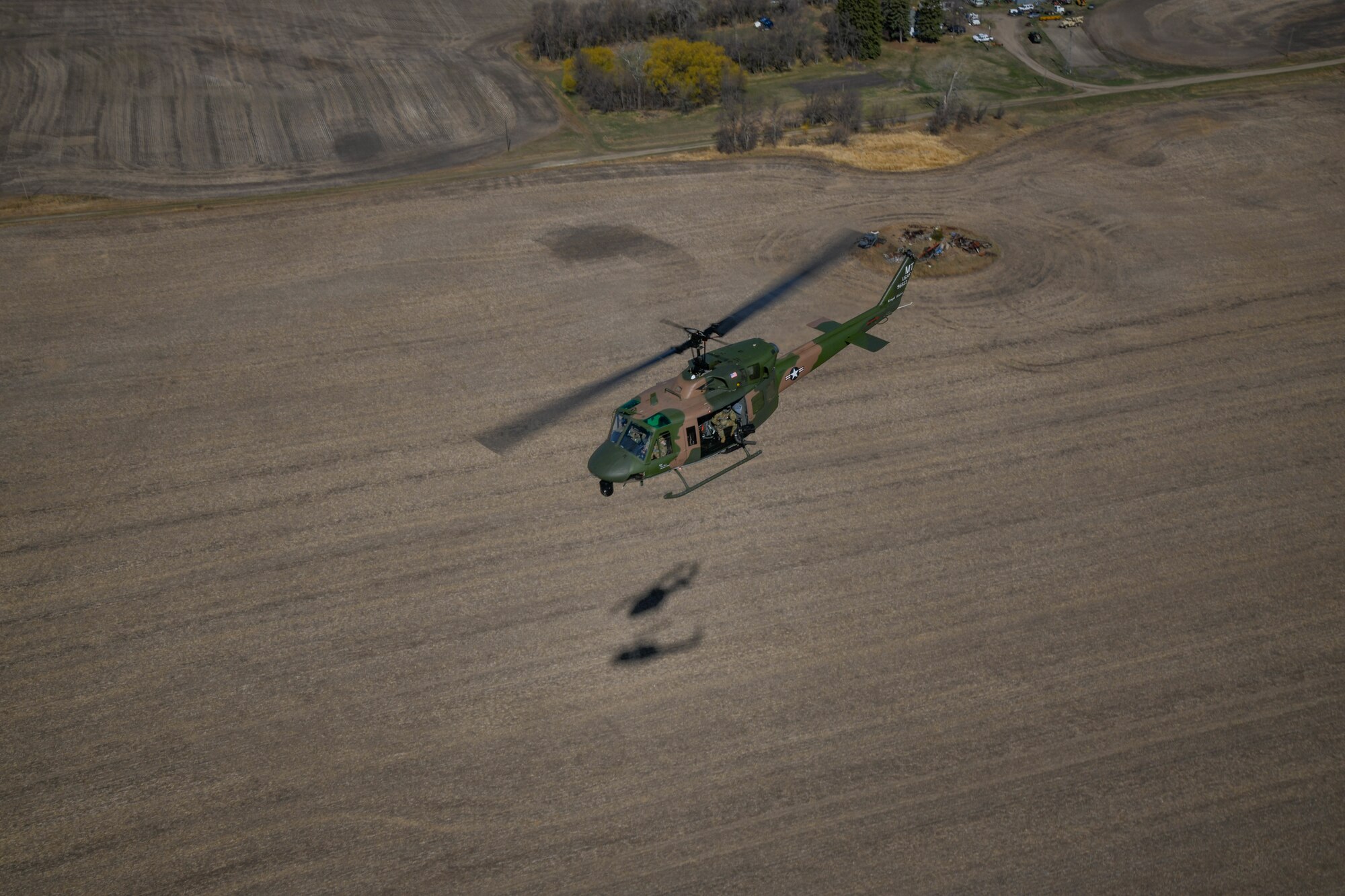 helicopter flies over field