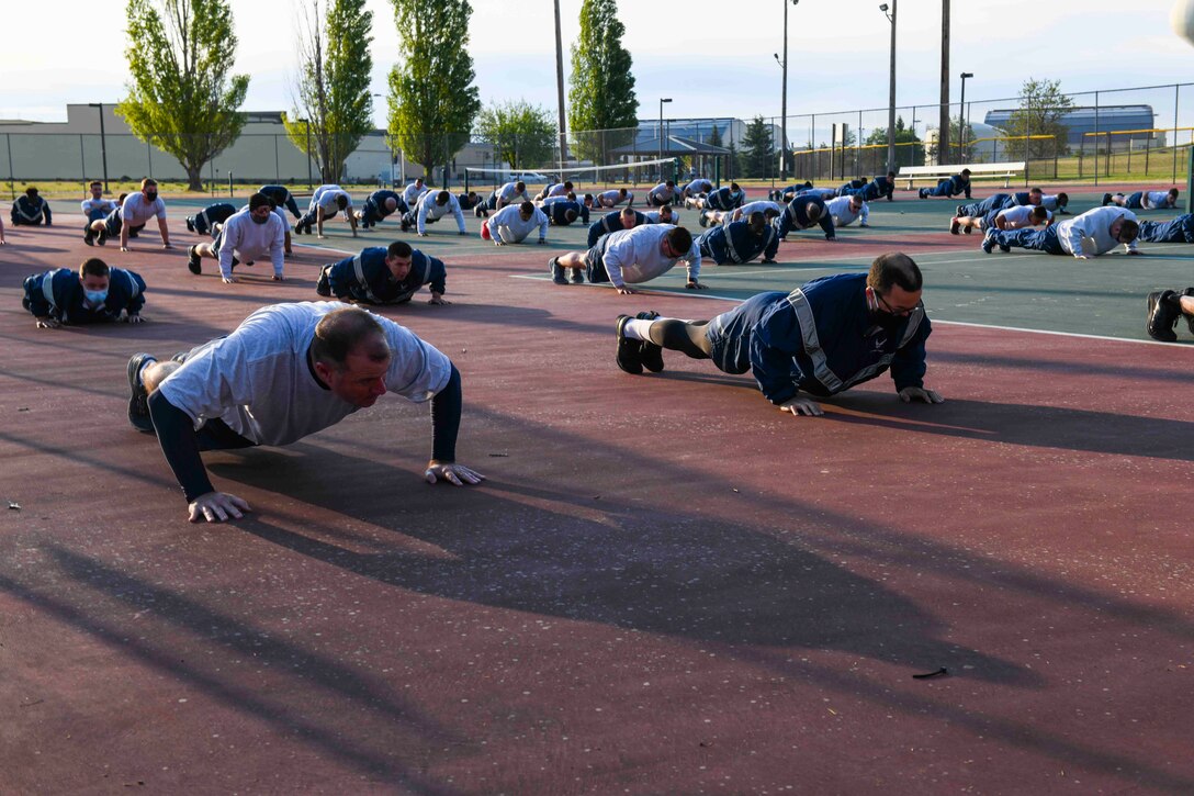 Maj. Gen. Thad Bibb, 18th Air Force commander, does push-ups with the 92nd Civil Engineering Squadron during their morning physical training, on Fairchild Air Force Base, Washington, May 21, 2021.