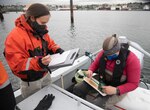 Alicia Higgs  and Kinsey Frick record and measure fish in the waters surrounding NSE, Washington, May 20, 2021.
