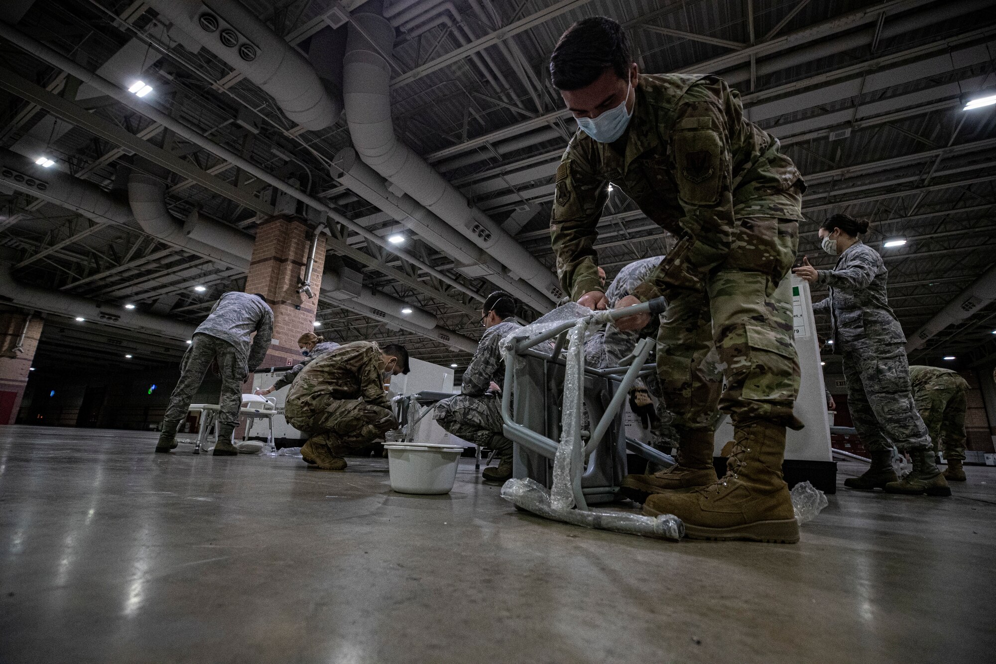 New Jersey Air National Guard Airmen set up equipment during the buildup of a Field Medical Station at the Atlantic City Convention Center in Atlantic City, N.J., April 9, 2020.  Atlantic City is one of three stations that will offer overflow from local hospitals focused on COVID-19 patients. (U.S. Air National Guard photo by Master Sgt. Matt Hecht)
