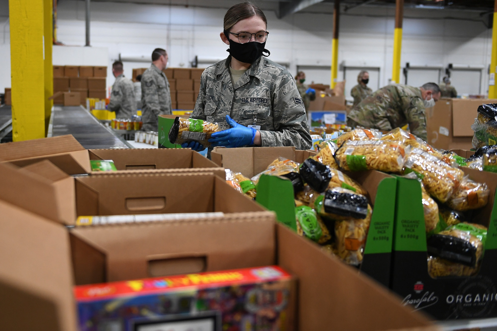 Airman 1st Class Grace Tesch, 141st Medical Group, packs food boxes at the Food Lifeline Covid Response warehouse April 23, 2020 in Seattle, Wash. More than 250 Air and Army National Guardsmen are assigned to the warehouse where they are able to prepare, on average, 268 boxes an hour.  (Air National Guard photo by Master Sgt. Tim Chacon)