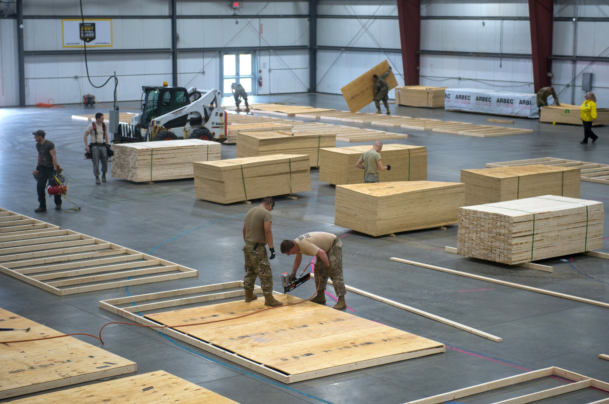 Airmen and soldiers from the Vermont National Guard work to construct a 400-bed medical surge facility at the Champlain Valley Exposition, Essex Junction, Vermont, April 04, 2020. The Vermont National Guard is working with the state of Vermont and emergency response partners in a whole-of-government effort to flatten the curve during the COVID-19 pandemic. (U.S. Air National Guard photo by Miss Julie M. Shea)