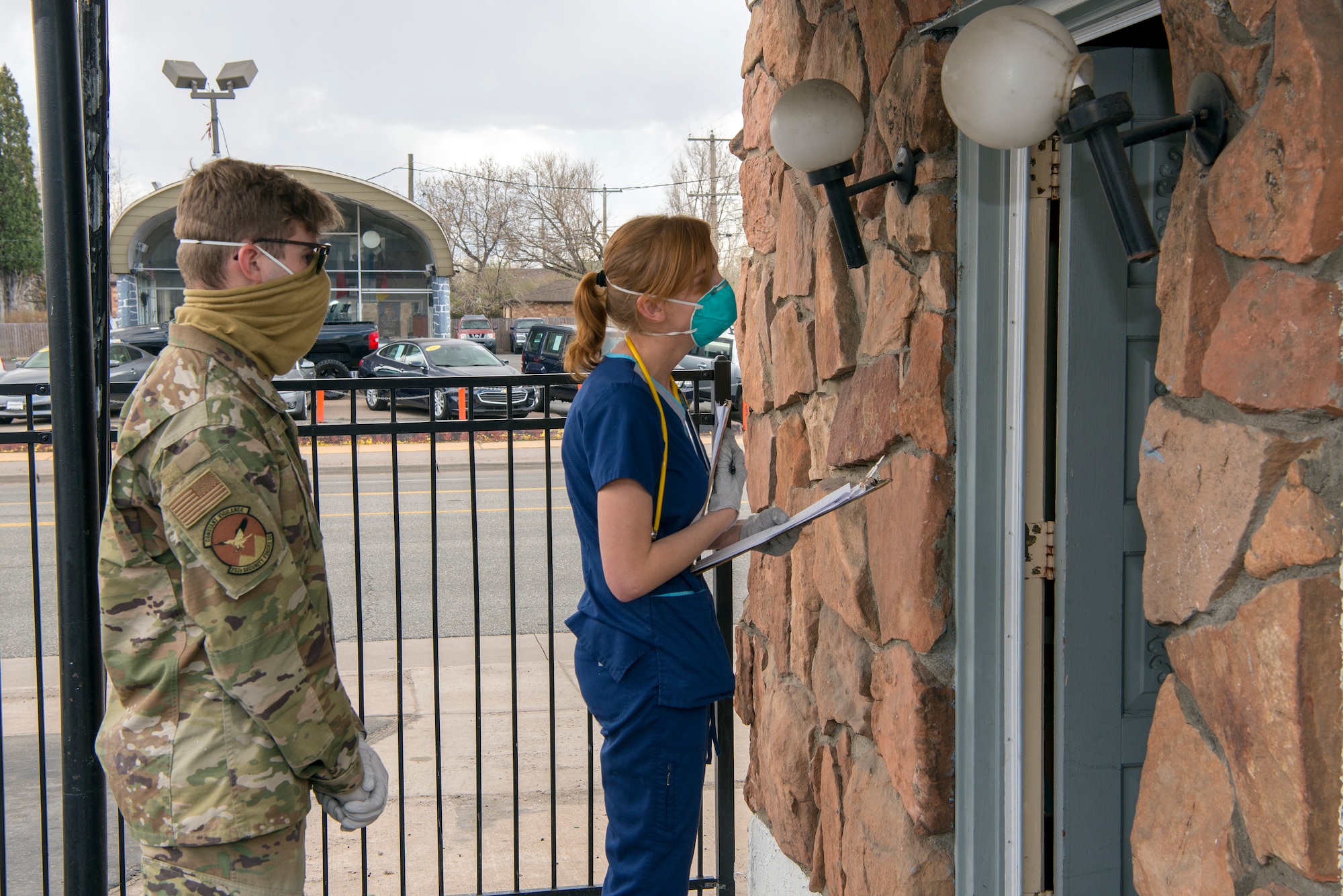 U.S. Air National Guard Airman 1st Class Ryan Terry, 233rd Space Warning Squadron security forces, assigned to Task Force Shelter Support for the Colorado National Guard’s COVID-19 response, along with volunteer nurse Rebekah Maciorowski, performs a wellness check to a resident at a motel where people without homes are lodged, Denver, Colo., April 10, 2020. Members of the Colorado National Guard volunteer to support state and local officials combat the Corona Virus Pandemic by assisting multiple agencies in the state of Colorado. (U.S. Air National Guard photo by Senior Master Sgt. John Rohrer)