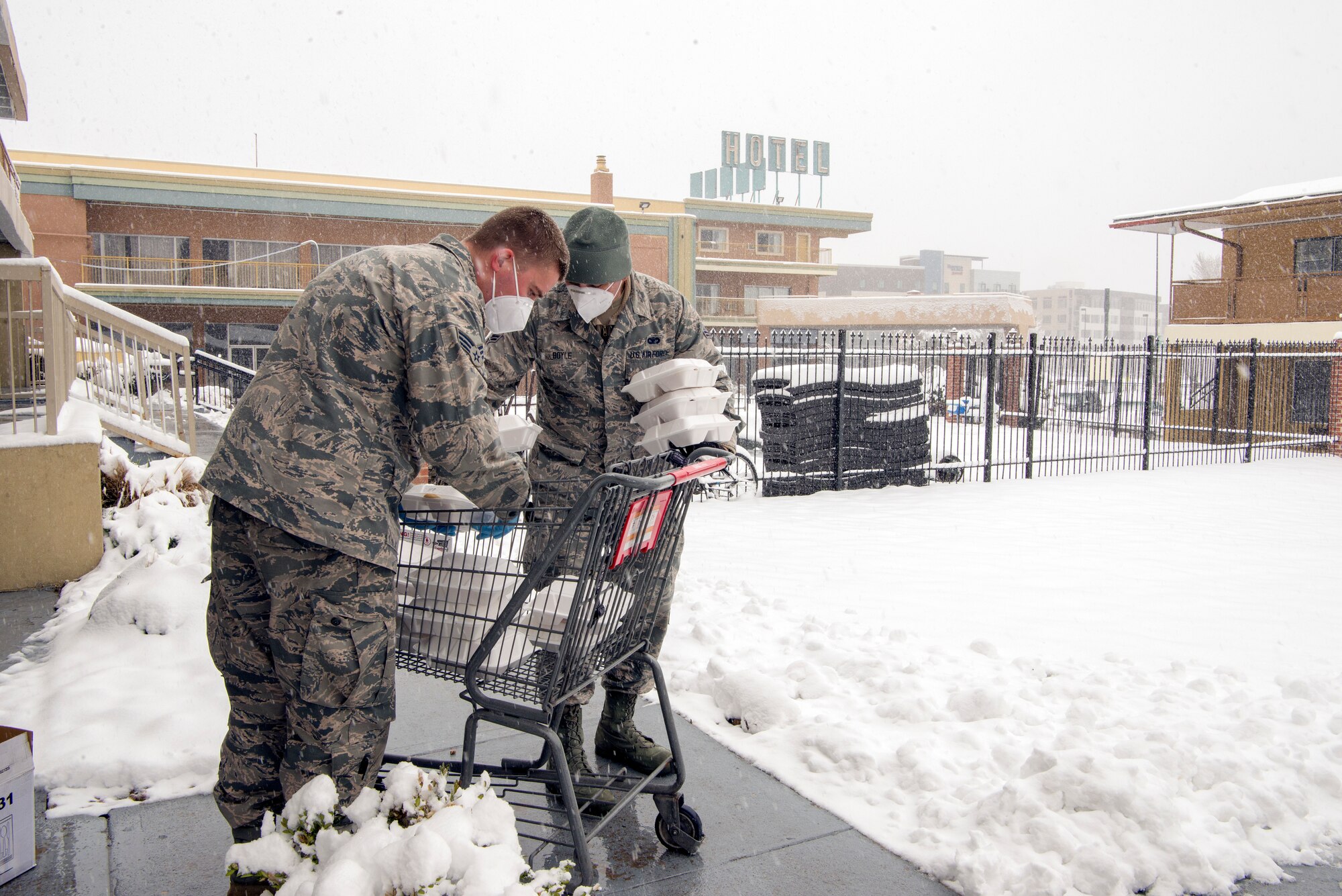 U.S. Air Force Senior Airman Konnor Ewing, a 140th Wing, Colorado Air National Guard aircraft structural maintenance mechanic, and Airman 1st Class John Boyle, 233rd Space Group security forces specialists in Greeley Colo., deliver meals to guests at a hotel in Denver, April 16, 2020.  Members of the Colorado National Guard have been brought on to serve in one of a multitude of task forces including helping those who otherwise would not have a place to stay during COVID 19. Troops are deployed around the state in various capacities to support state and local officials combat the Corona Virus Pandemic. (U.S. Air National Guard photo by Senior Master Sgt. John Rohrer)