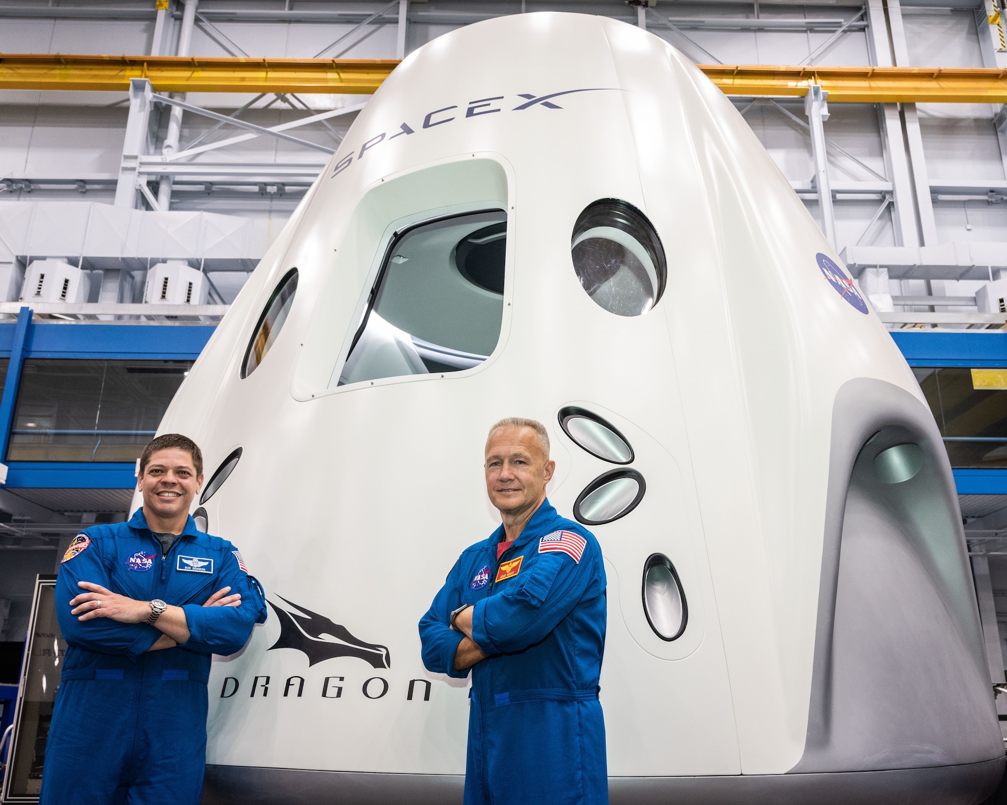 NASA astronauts Bob Behnken and Doug Hurley, assigned to fly on the first test flight of SpaceX’s Crew Dragon, pose in front of a mockup of the spacecraft at NASA’s Johnson Space Center in Houston, Texas on Aug. 2, 2018 ahead of the agency’s announcement of their commercial crew assignment Aug. 3.  Nine U.S. astronauts were selected for commercial crew flight assignments on the first test flights and operational missions for Boeing’s CST-100 Starliner and SpaceX’s Crew Dragon. Photo Credit: (NASA/Robert Markowitz)