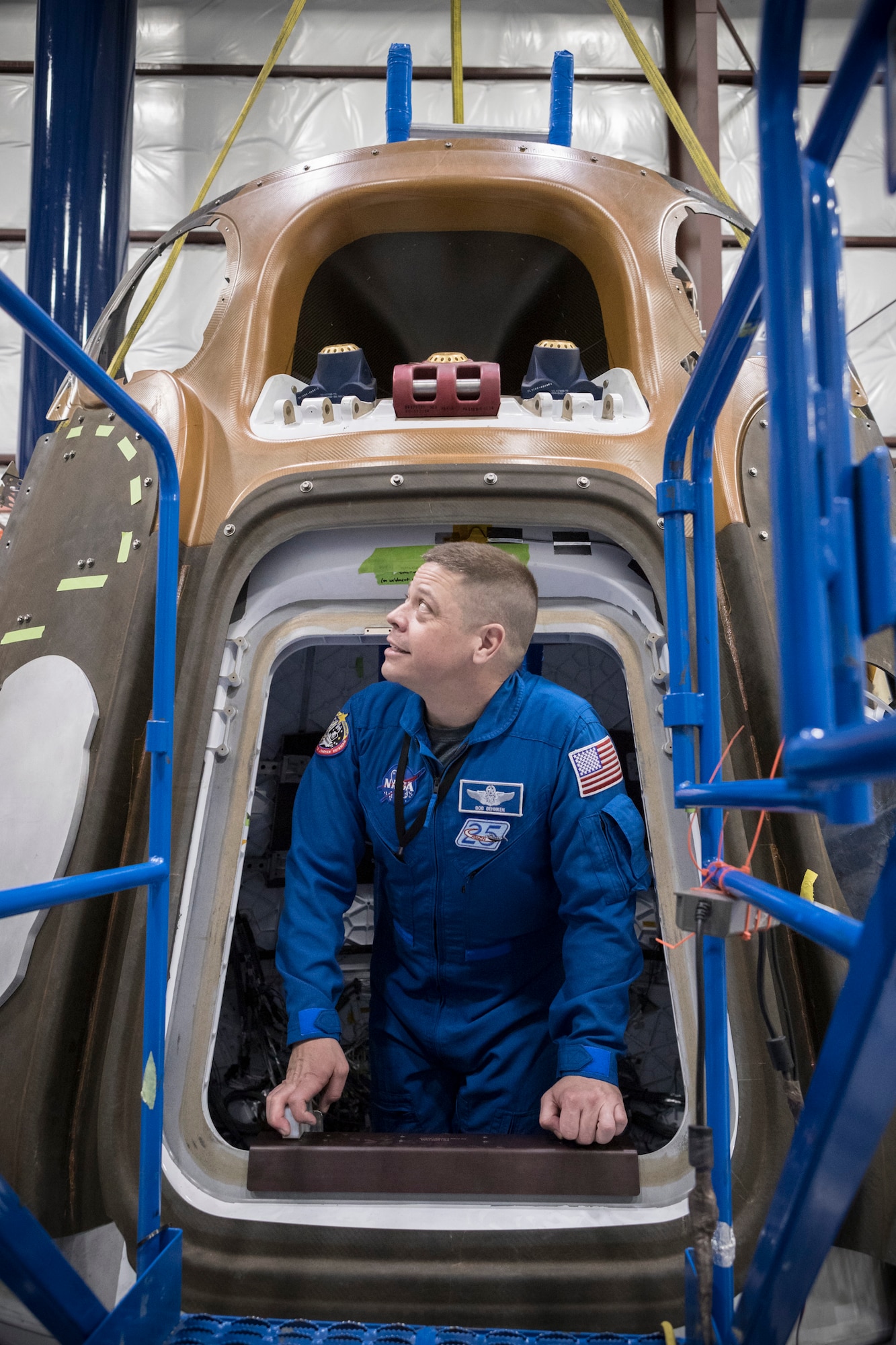 Astronaut USAF Col. Bob Behnken emerges from the hatch of a SpaceX Crew Dragon spacecraft being manufactured at SpaceX's headquarters and factory in Hawthorne, California, March 8, 2017. Behnken is one of four NASA astronauts selected to train with Boeing and SpaceX ahead of flight tests for NASA's Commercial Crew Program to develop launch vehicles to take astronauts to the International Space Station. (Photo/SpaceX)