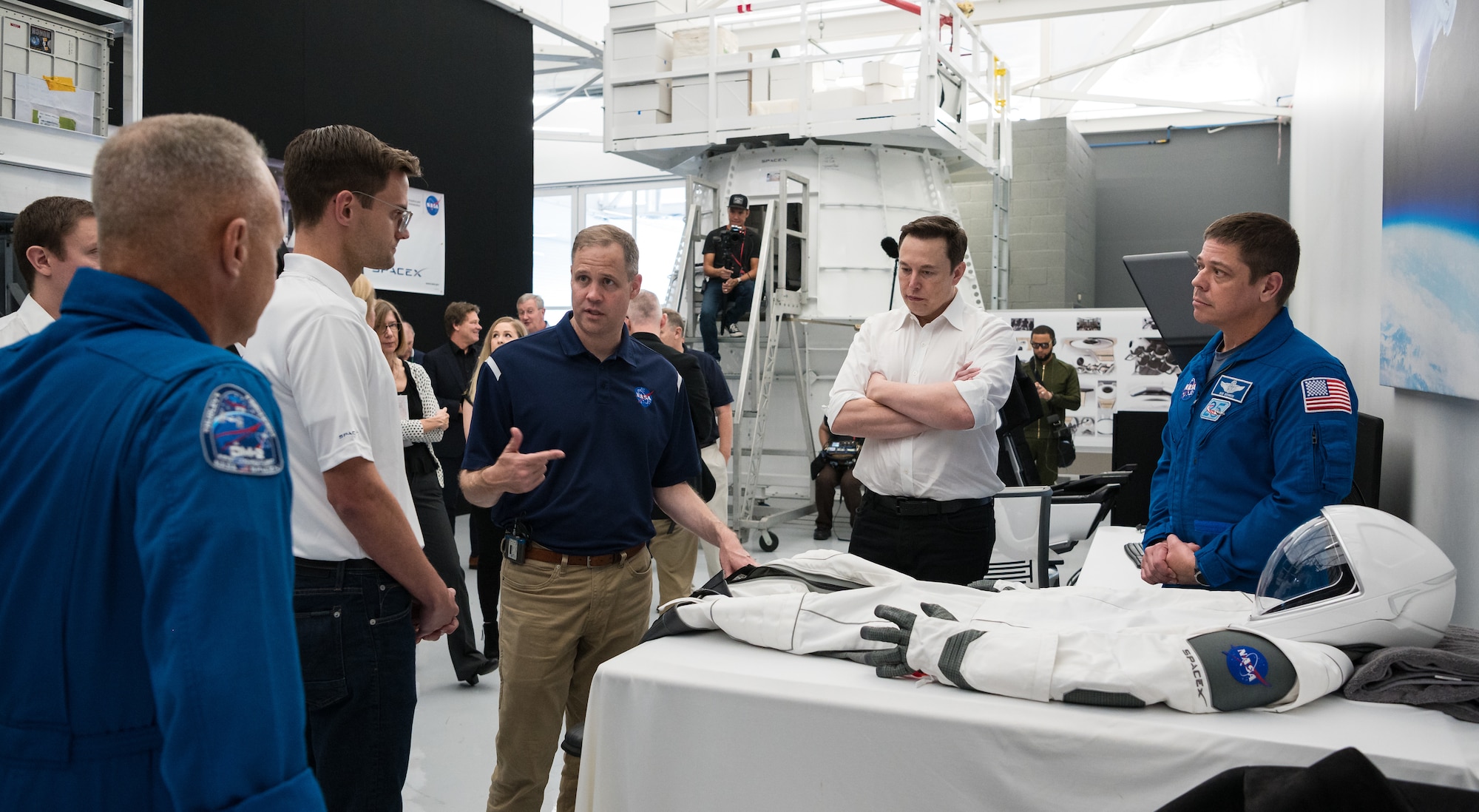 SpaceX Chief Engineer Elon Musk, second from right, and NASA astronaut Bob Behnken, right, look on as NASA Administrator Jim Bridenstine, third from left, speaks to NASA astronaut Doug Hurley, left, as they look at an identical version of the SpaceX spacesuit that he will wear for the Demo-2 mission during a visit to SpaceX Headquarters, Thursday, Oct. 10, 2019 in Hawthorne, CA. Behnken and Hurley are assigned to fly onboard Crew Dragon for the Demo-2 mission. Photo credit: (NASA/Aubrey Gemignani)