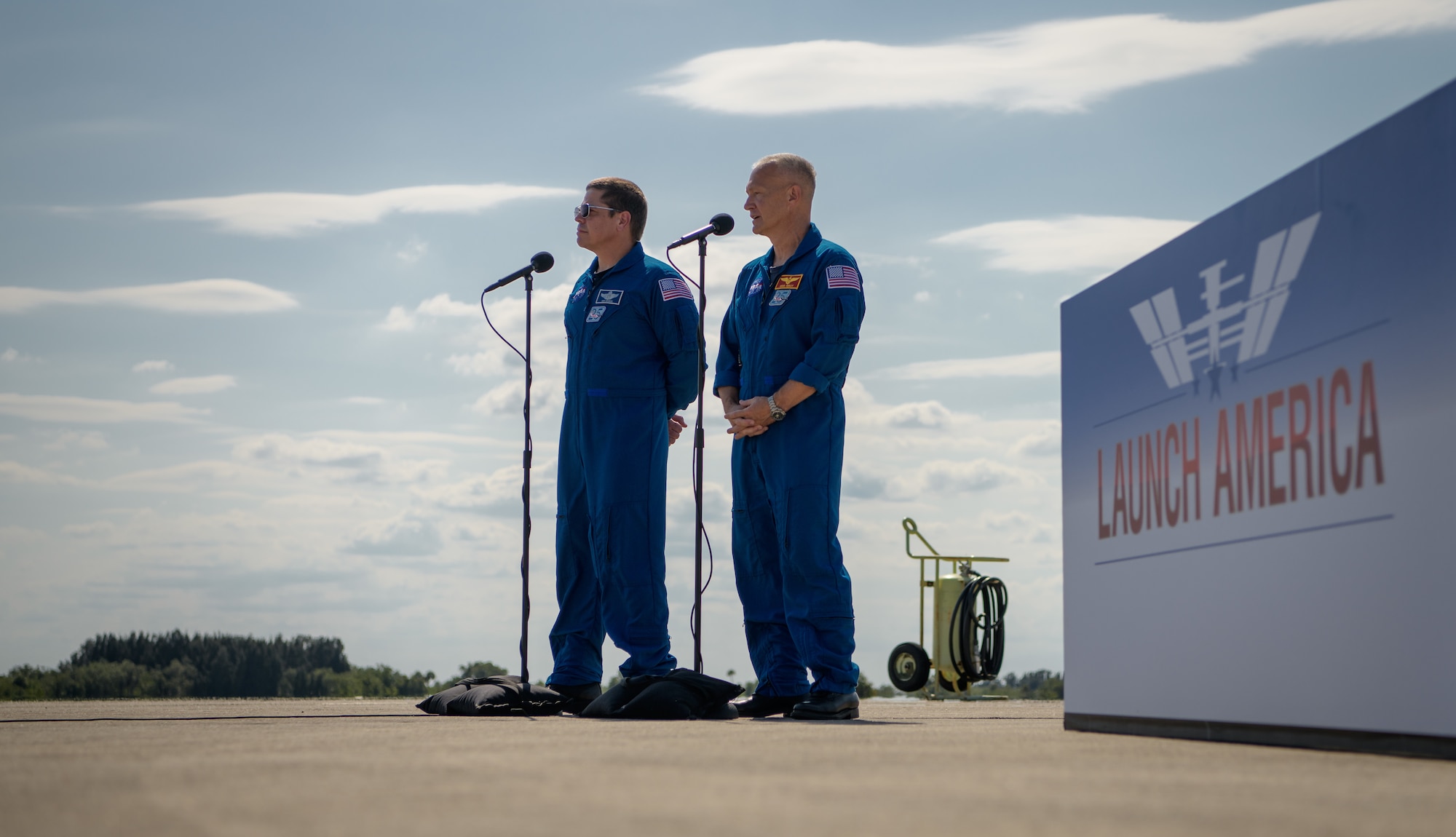 NASA astronauts Robert Behnken, left, and Douglas Hurley speak to members of the media after arriving at the Launch and Landing Facility at NASA’s Kennedy Space Center ahead of SpaceX’s Demo-2 mission, Wednesday, May 20, 2020, in Florida. NASA’s SpaceX Demo-2 mission is the first launch with astronauts of the SpaceX Crew Dragon spacecraft and Falcon 9 rocket to the International Space Station as part of the agency’s Commercial Crew Program. The flight test will serve as an end-to-end demonstration of SpaceX’s crew transportation system. Behnken and Hurley are scheduled to launch at 4:33 p.m. EDT on Wednesday, May 27, from Launch Complex 39A at the Kennedy Space Center. A new era of human spaceflight is set to begin as American astronauts once again launch on an American rocket from American soil to low-Earth orbit for the first time since the conclusion of the Space Shuttle Program in 2011.  Photo Credit: (NASA/Bill Ingalls)