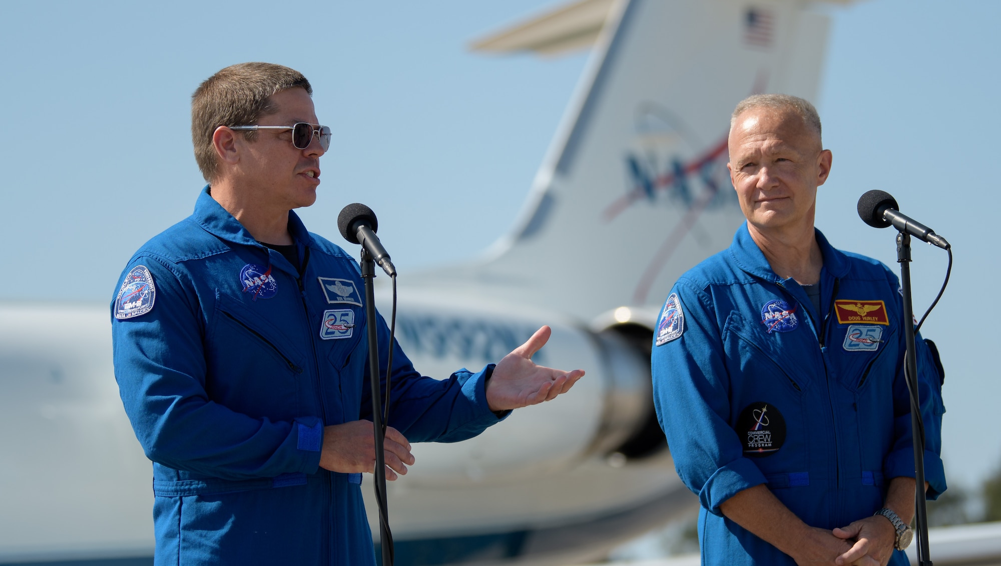 NASA astronauts Robert Behnken, left, and Douglas Hurley speak to members of the media after arriving at the Launch and Landing Facility at NASA’s Kennedy Space Center ahead of SpaceX’s Demo-2 mission, Wednesday, May 20, 2020, in Florida. NASA’s SpaceX Demo-2 mission is the first launch with astronauts of the SpaceX Crew Dragon spacecraft and Falcon 9 rocket to the International Space Station as part of the agency’s Commercial Crew Program. The flight test will serve as an end-to-end demonstration of SpaceX’s crew transportation system. Behnken and Hurley are scheduled to launch at 4:33 p.m. EDT on Wednesday, May 27, from Launch Complex 39A at the Kennedy Space Center. A new era of human spaceflight is set to begin as American astronauts once again launch on an American rocket from American soil to low-Earth orbit for the first time since the conclusion of the Space Shuttle Program in 2011.  Photo Credit: (NASA/Bill Ingalls)