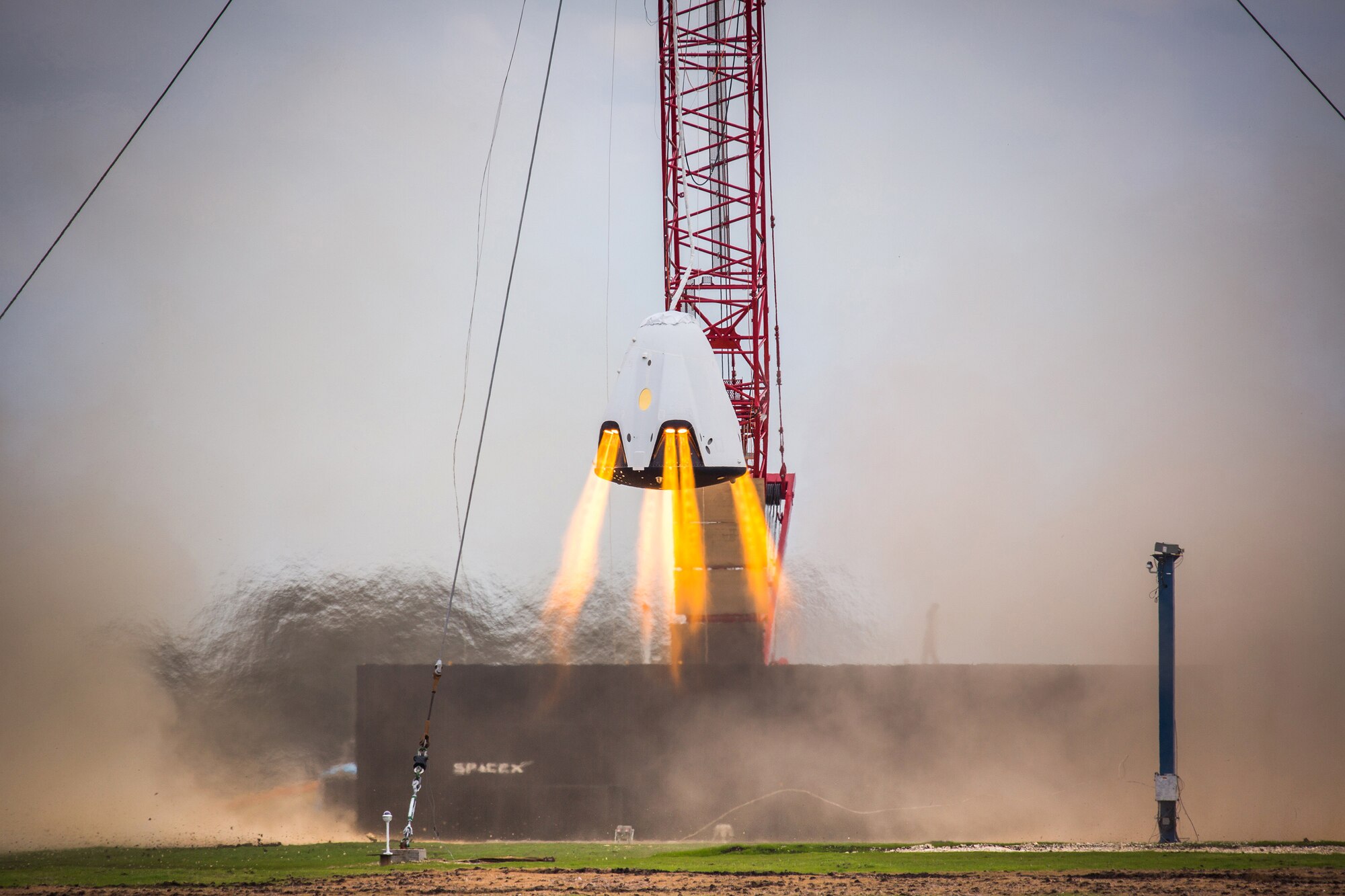 SpaceX performing a Propulsive Descent Landing with their Dragon capsule at the SpaceX Test Facility in McGregor, Texas