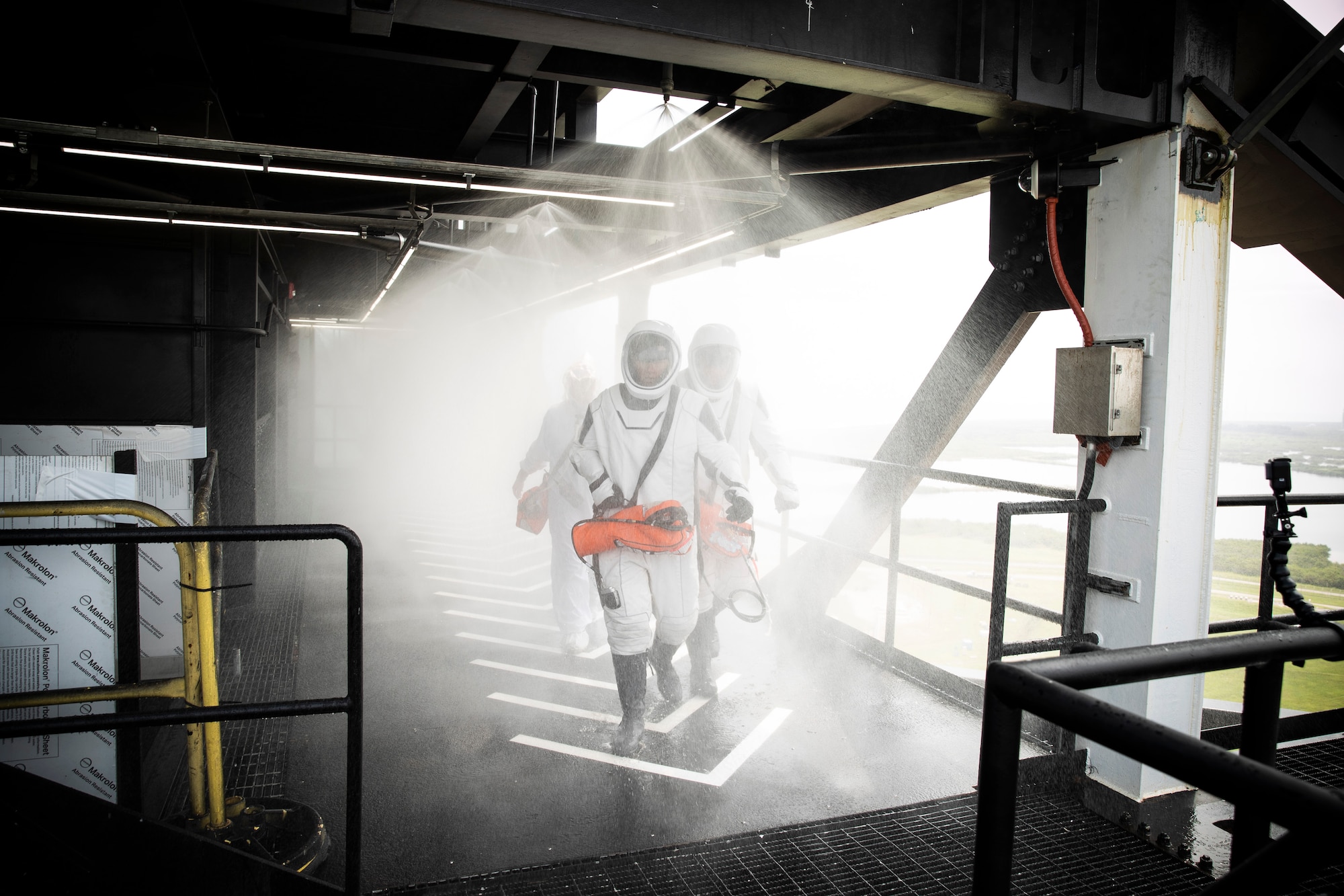 NASA and SpaceX conducted a formal verification of the company’s emergency escape system on Sept. 18, 2019, at Kennedy Space Center’s Launch Complex 39A in Florida. NASA astronauts Shannon Walker, in front, and Bob Behnken participated in the exercise to verify the crew can safely and quickly evacuate from the launch pad in the unlikely event of an emergency before liftoff of SpaceX’s first crewed flight test, called Demo-2. During the escape verification, Walker and Behnken pass through the water deluge system on the 265-foot level of the crew access tower. As Boeing and SpaceX begin to make regular flights to the International Space Station for NASA’s Commercial Crew Program, the agency will continue to advance its mission to go beyond low-Earth orbit and establish a human presence on the Moon with the ultimate goal of sending astronauts to Mars.