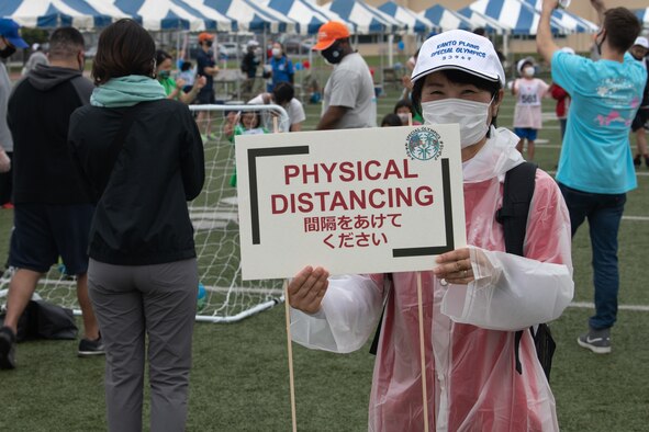 A volunteer displays a physical distancing sign during the Kanto Plains Special Olympics