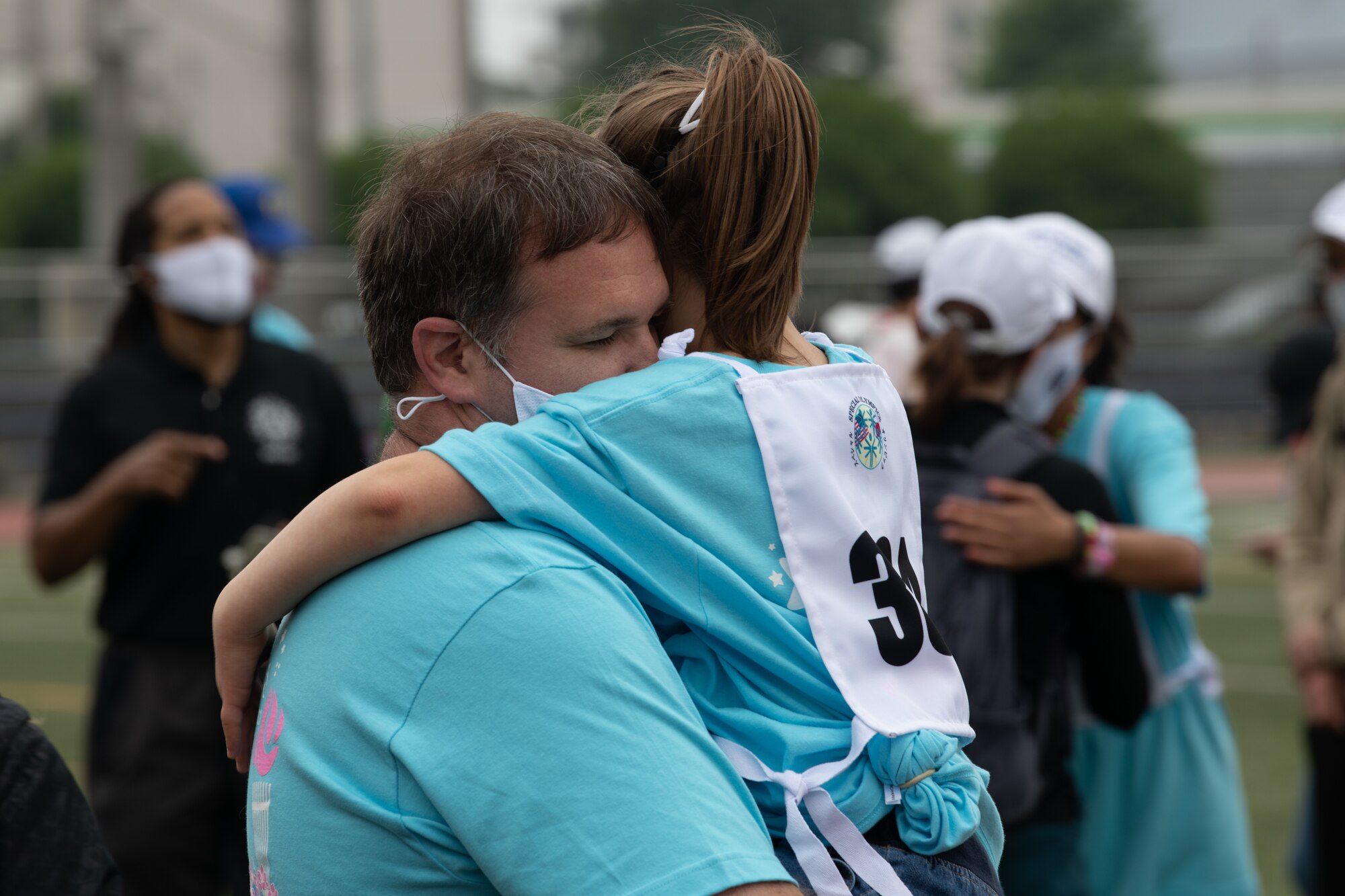 A parent and athlete embrace each other during the Kanto Plains Special Olympics