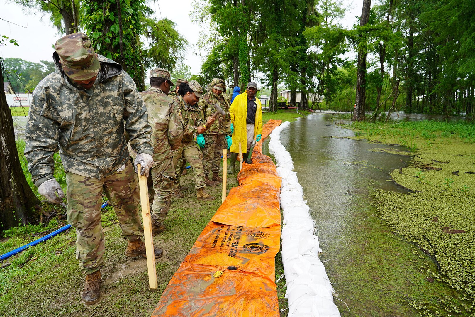 Louisiana National Guardsmen deliver and set up a Tiger Dam system, a series of water-filled tubes that create a barrier to mitigate flooding, while assisting local and state officials in combating rising floodwaters in Pierre Part, La., May 21, 2021.