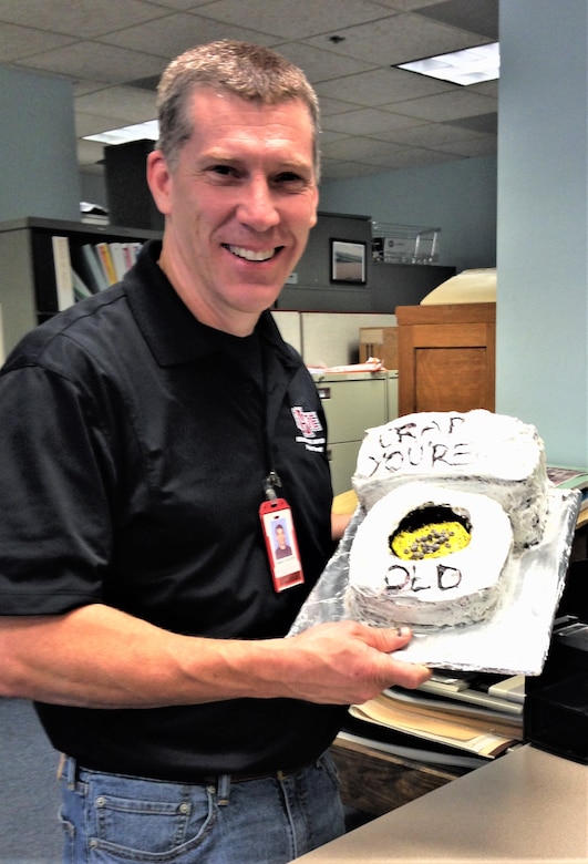 IN THE PHOTO, Darian Chasteen on his birthday, holding his birthday cake decorated with icing that says, "You are old". Chasteen recently passed away, losing a hard-fought battle with cancer. While he is physically no longer with the district, his legacy will live on through stories and memories forever.